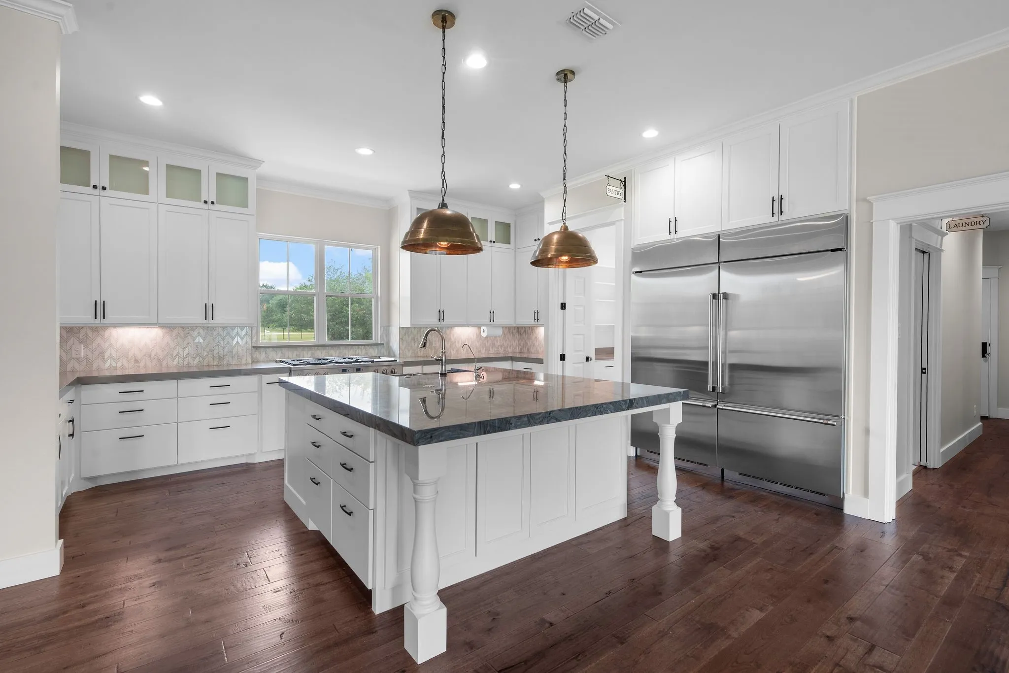 Gourmet kitchen with oversized island, quartz counters, Café appliances, and farmhouse sink.