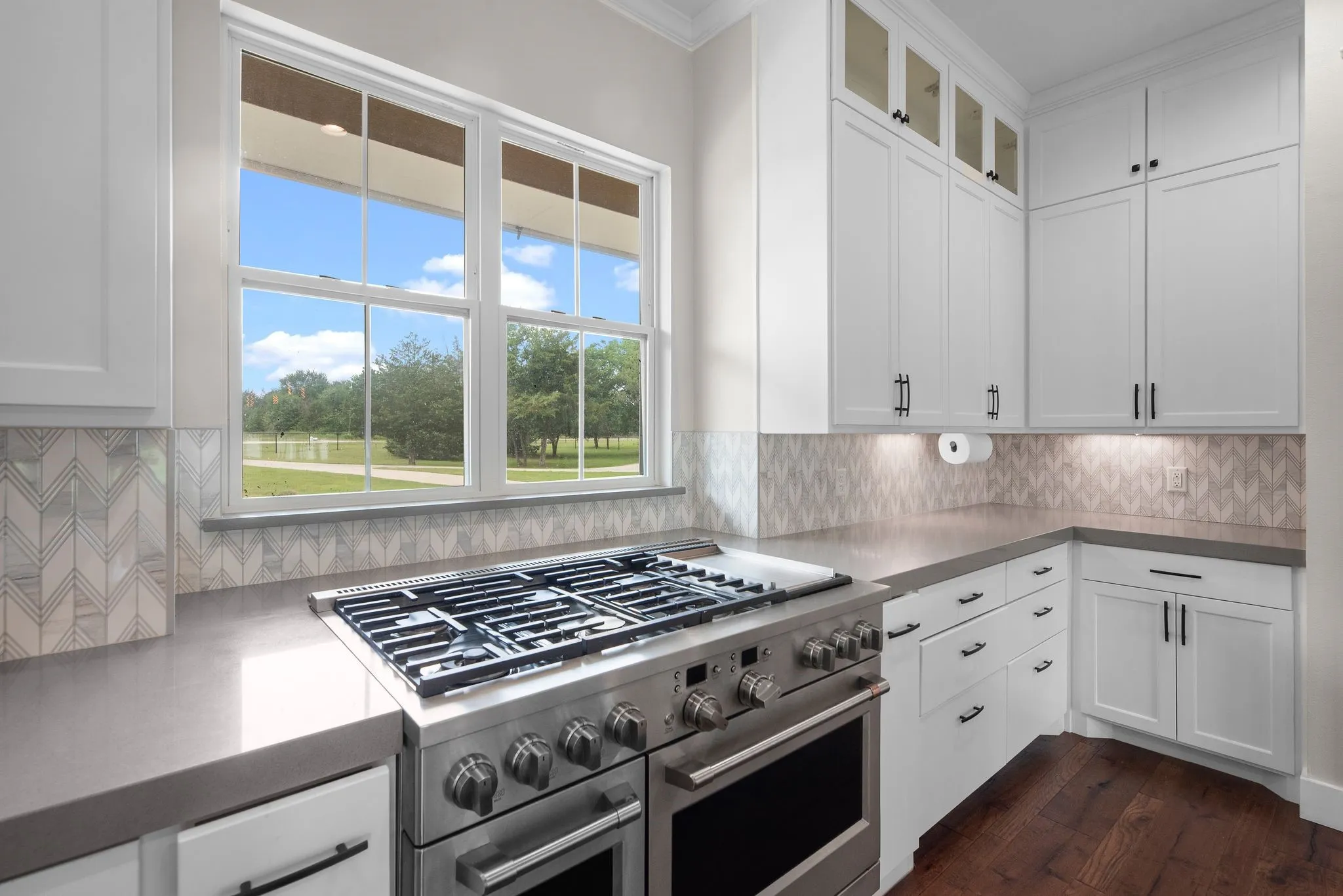 Commercial-grade gas range with scenic backyard views from the kitchen.