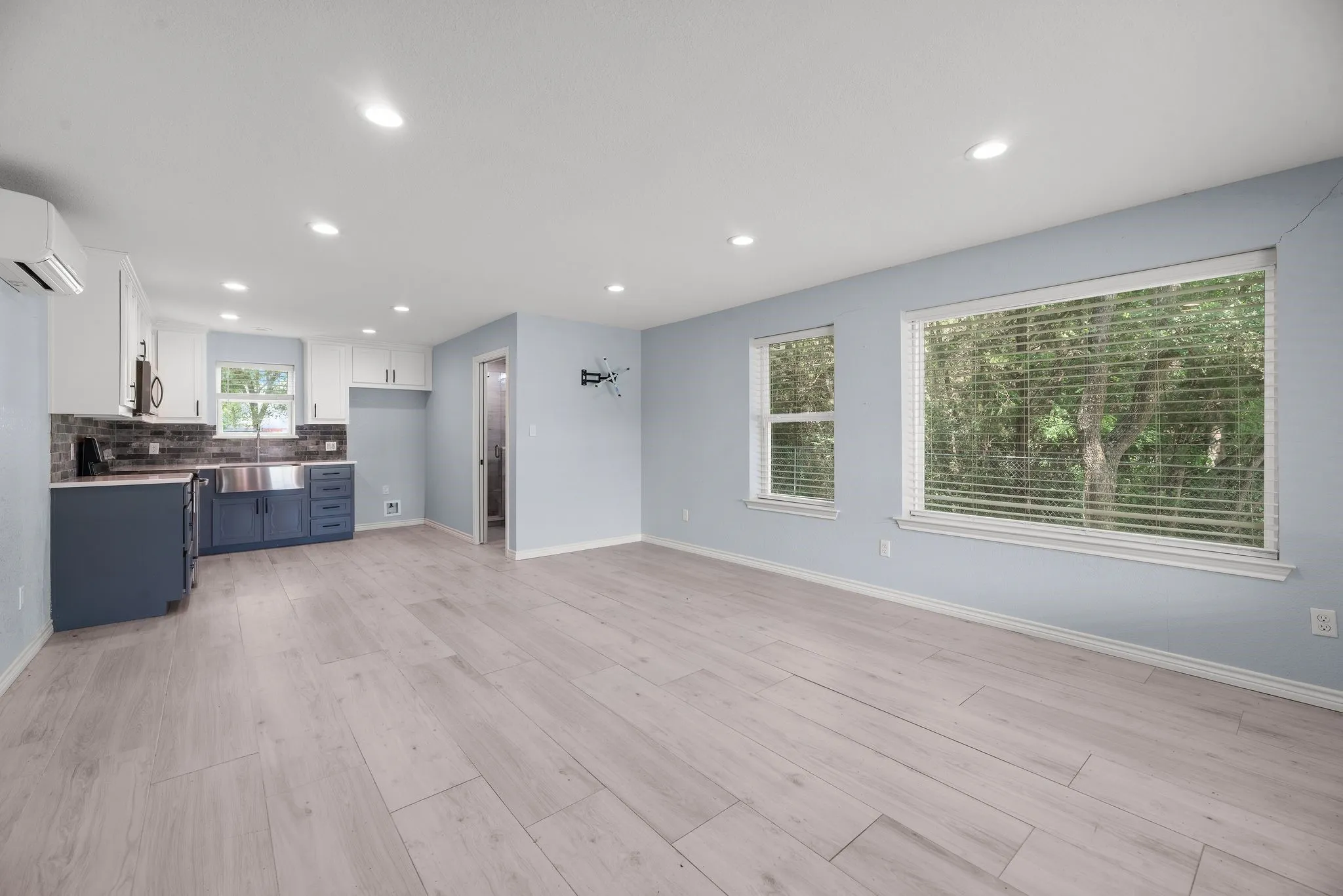 Guest apartment living area with bright windows and easy-care flooring.