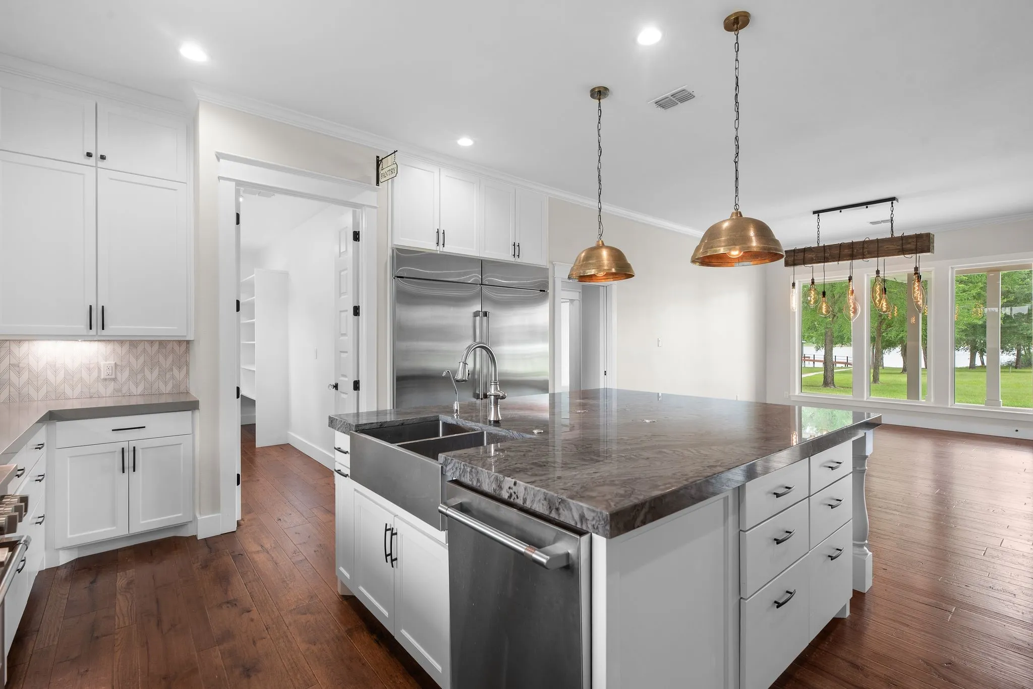 Designer kitchen with built-in refrigerator, gas range, and beautiful lake-facing windows.