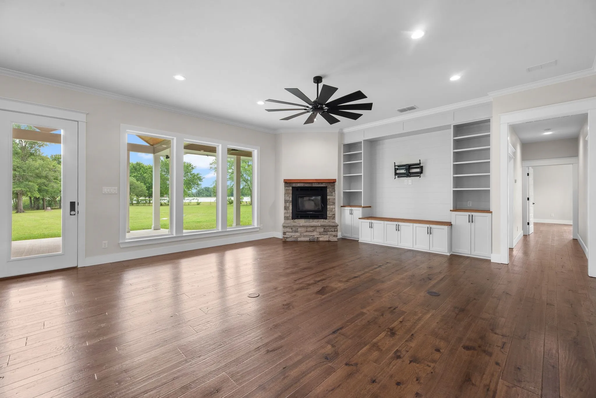 Spacious living room with wood-burning fireplace, built-ins, and wide lake-facing windows.