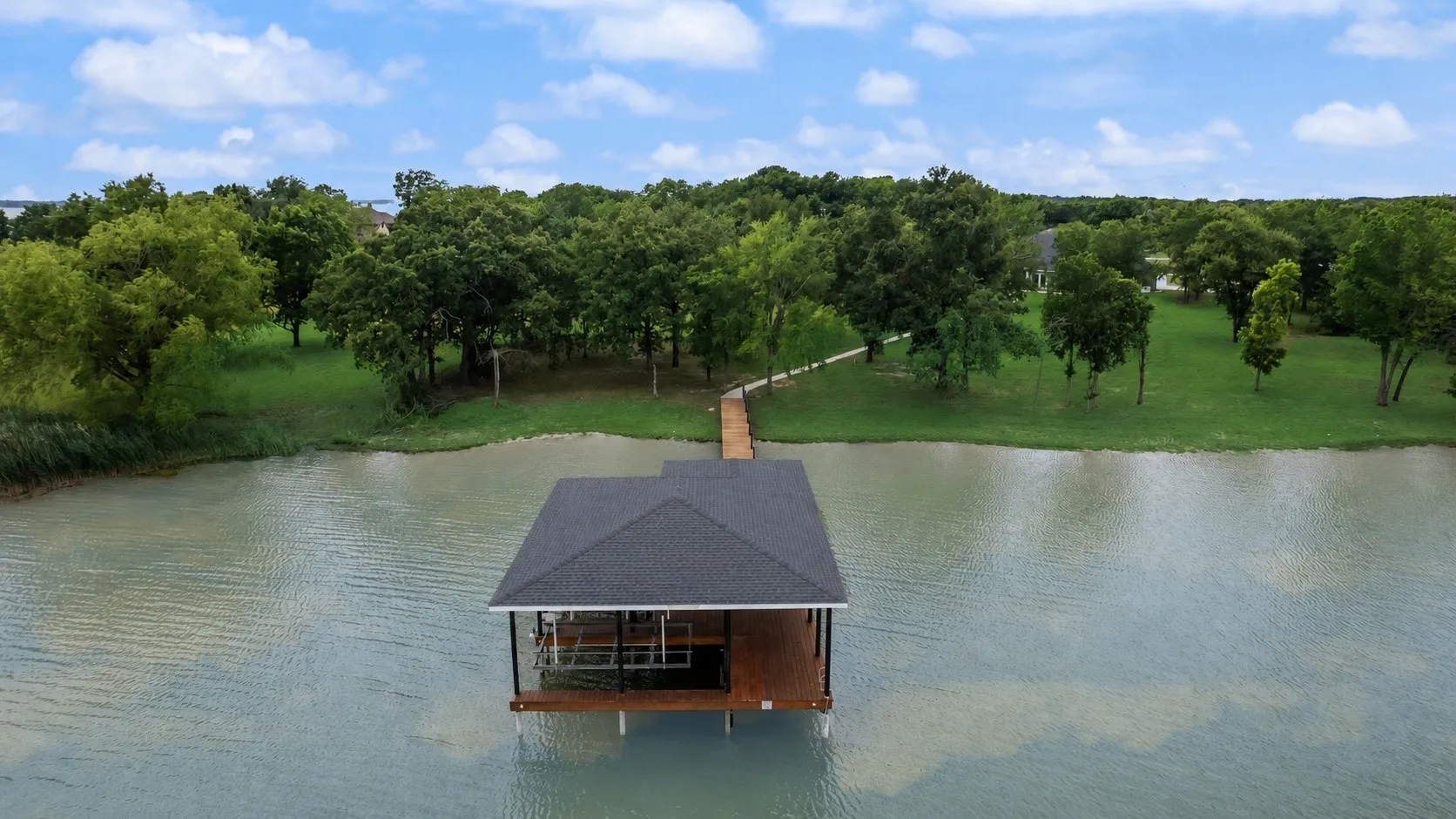 Aerial view of protected cove shoreline and private covered dock.