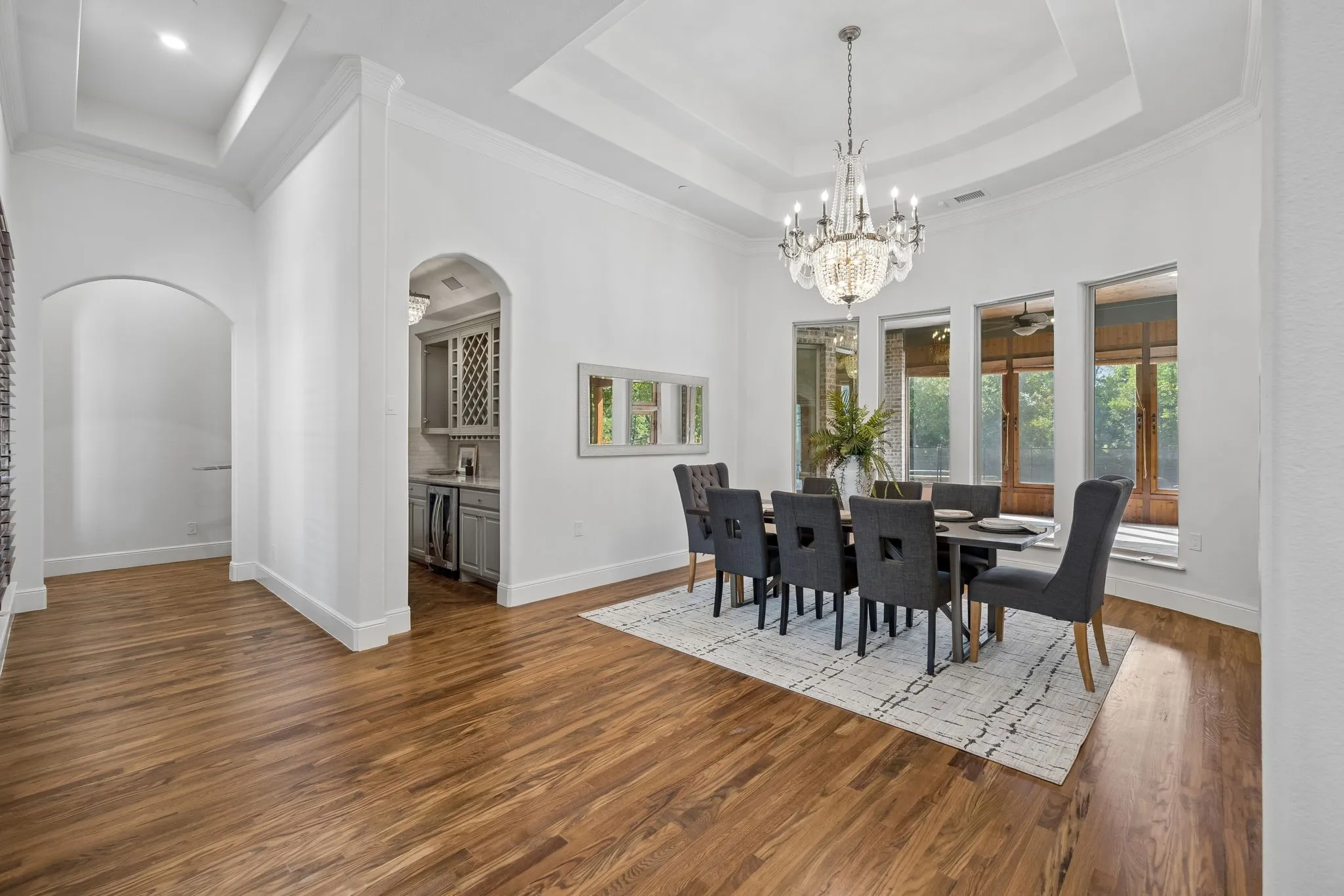 Formal dining space featuring wood-finish flooring and a tray ceiling with an elaborate chandelier