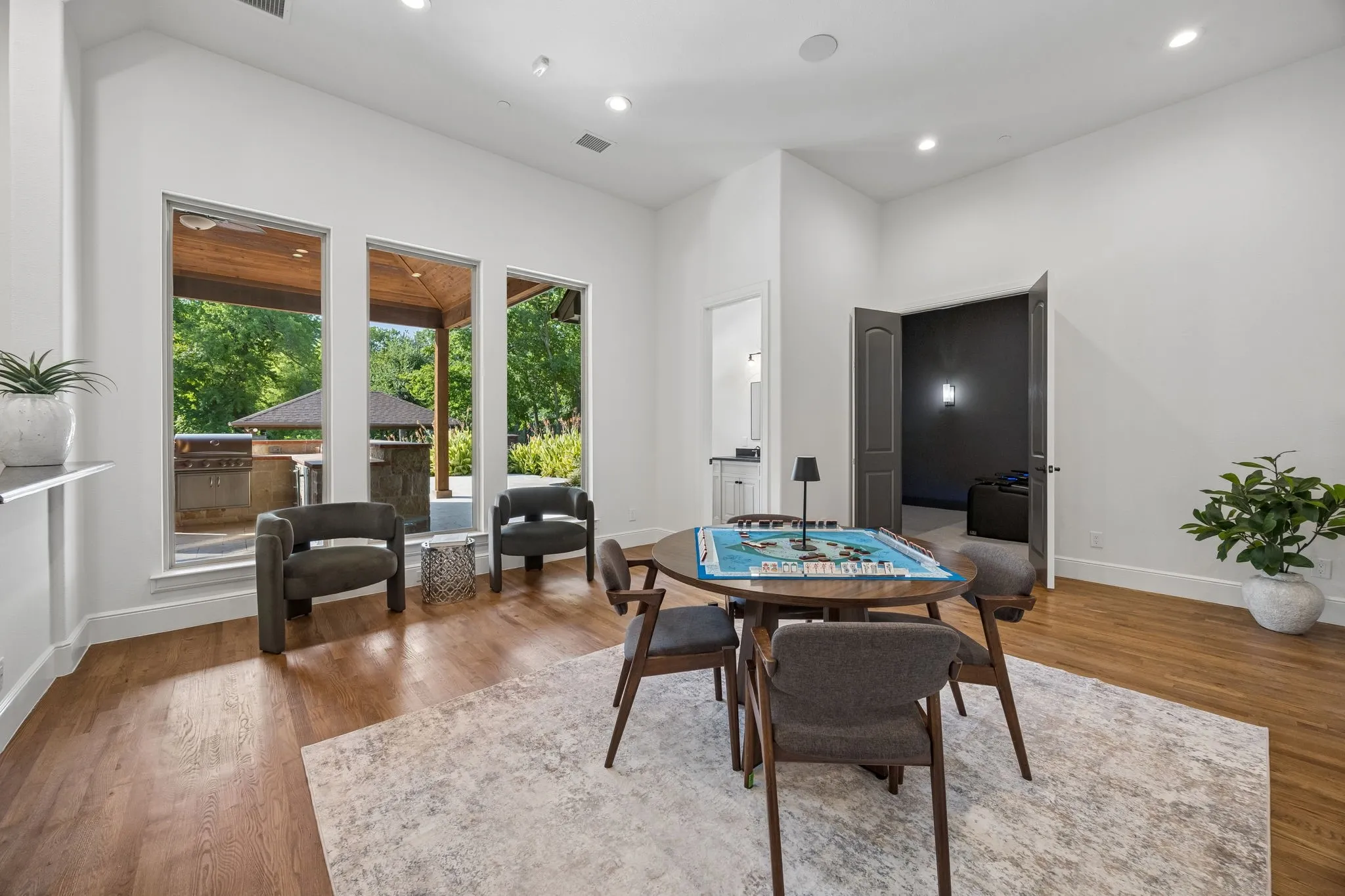 Open-concept room featuring wood-finish flooring, a neutral area rug, and recessed lighting
