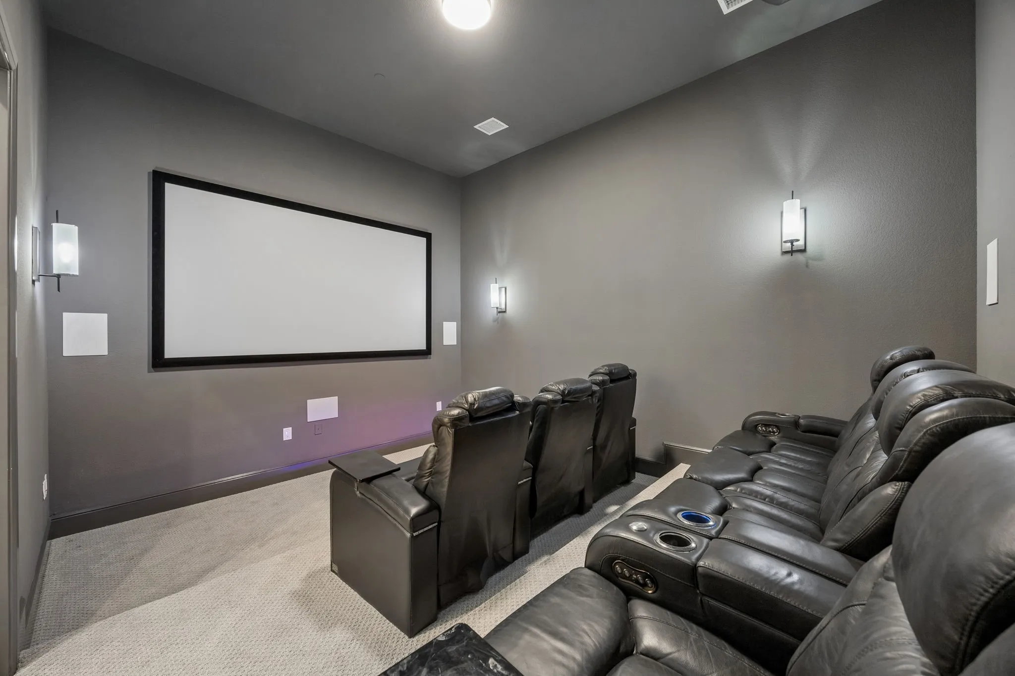 Dedicated media room featuring a large projection screen and integrated audio components