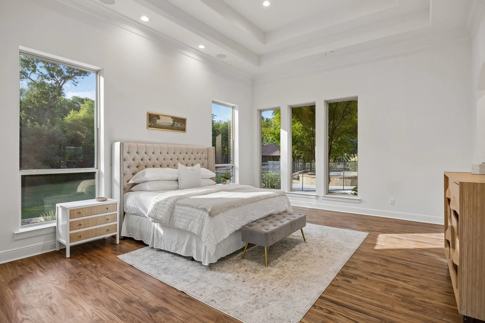 Spacious interior featuring wood-finish flooring and a tray ceiling with recessed lighting