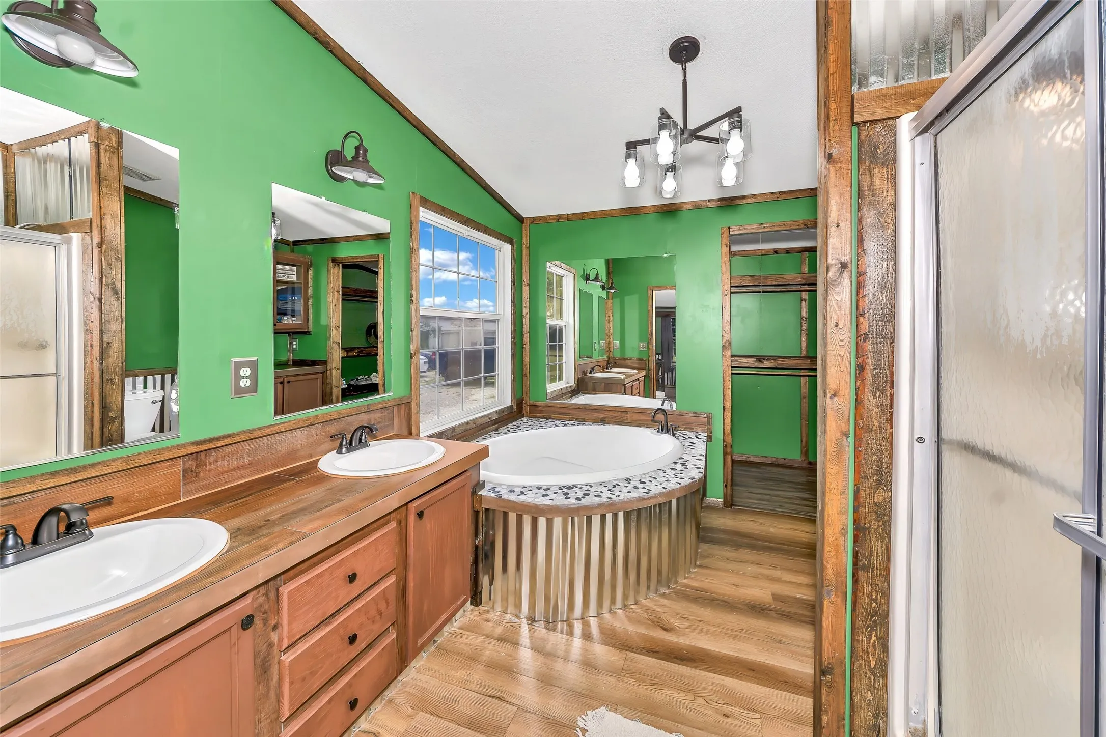 Dual vanity with undermount sinks and dark bronze fixtures, framed mirrors, and wood-finish countertops