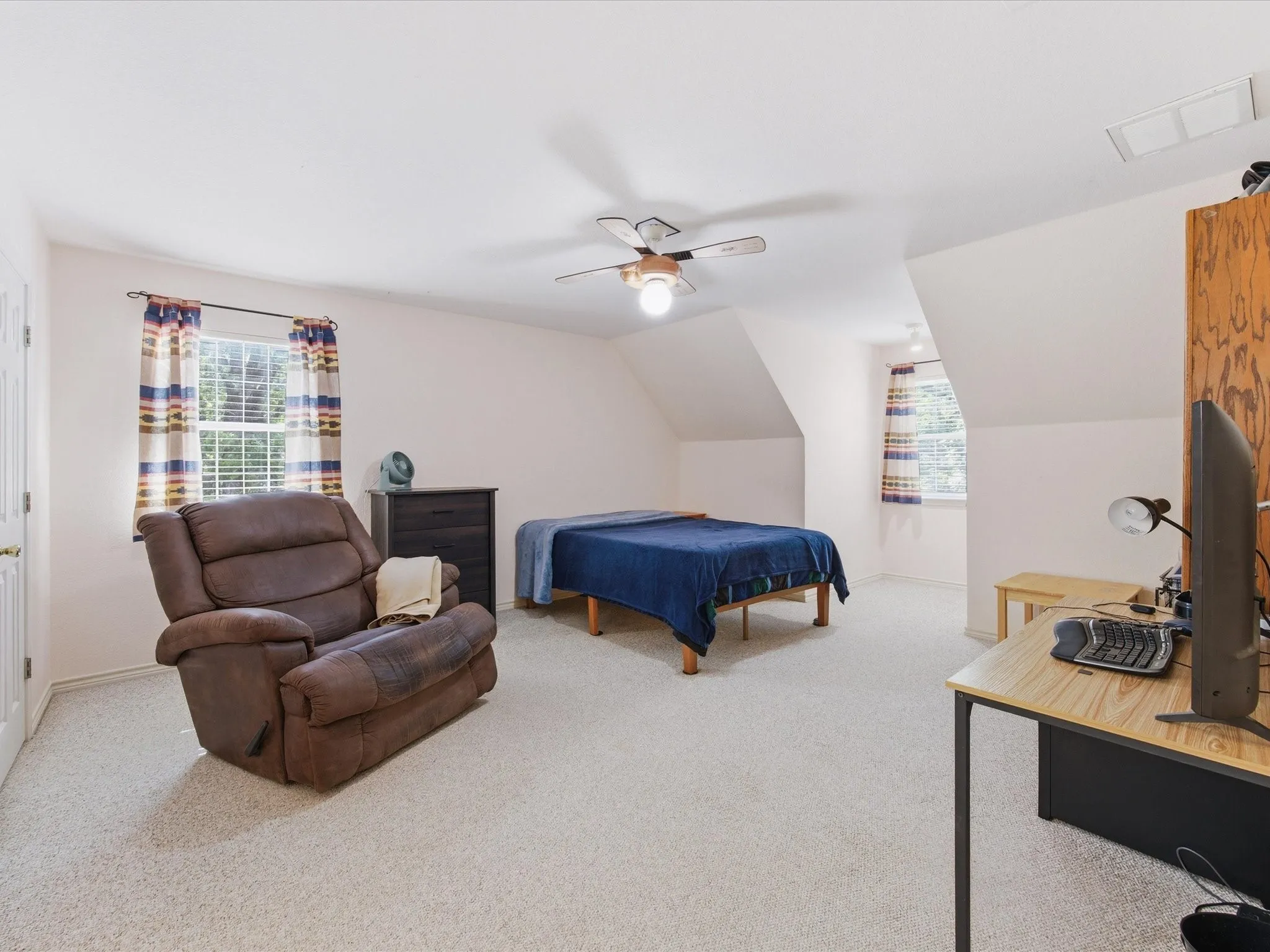 4th bedroom upstairs with ceiling fan, and windows with walk-in closet