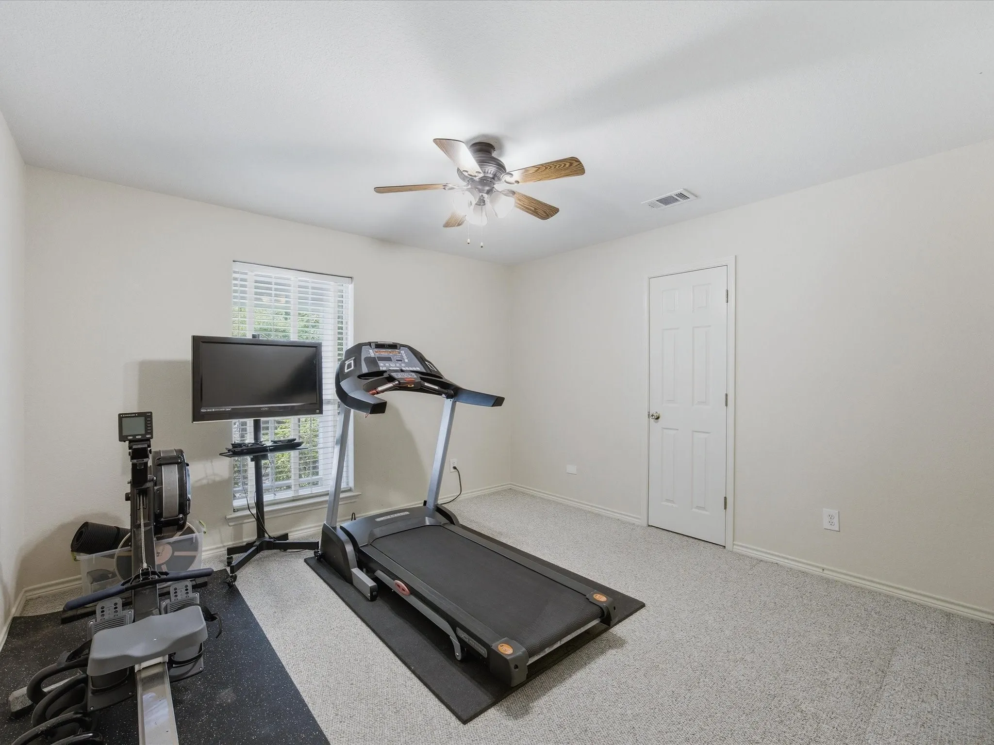 2nd bedroom on main floor with ceiling fan, window, walk-in closet and currently used as exercise room
