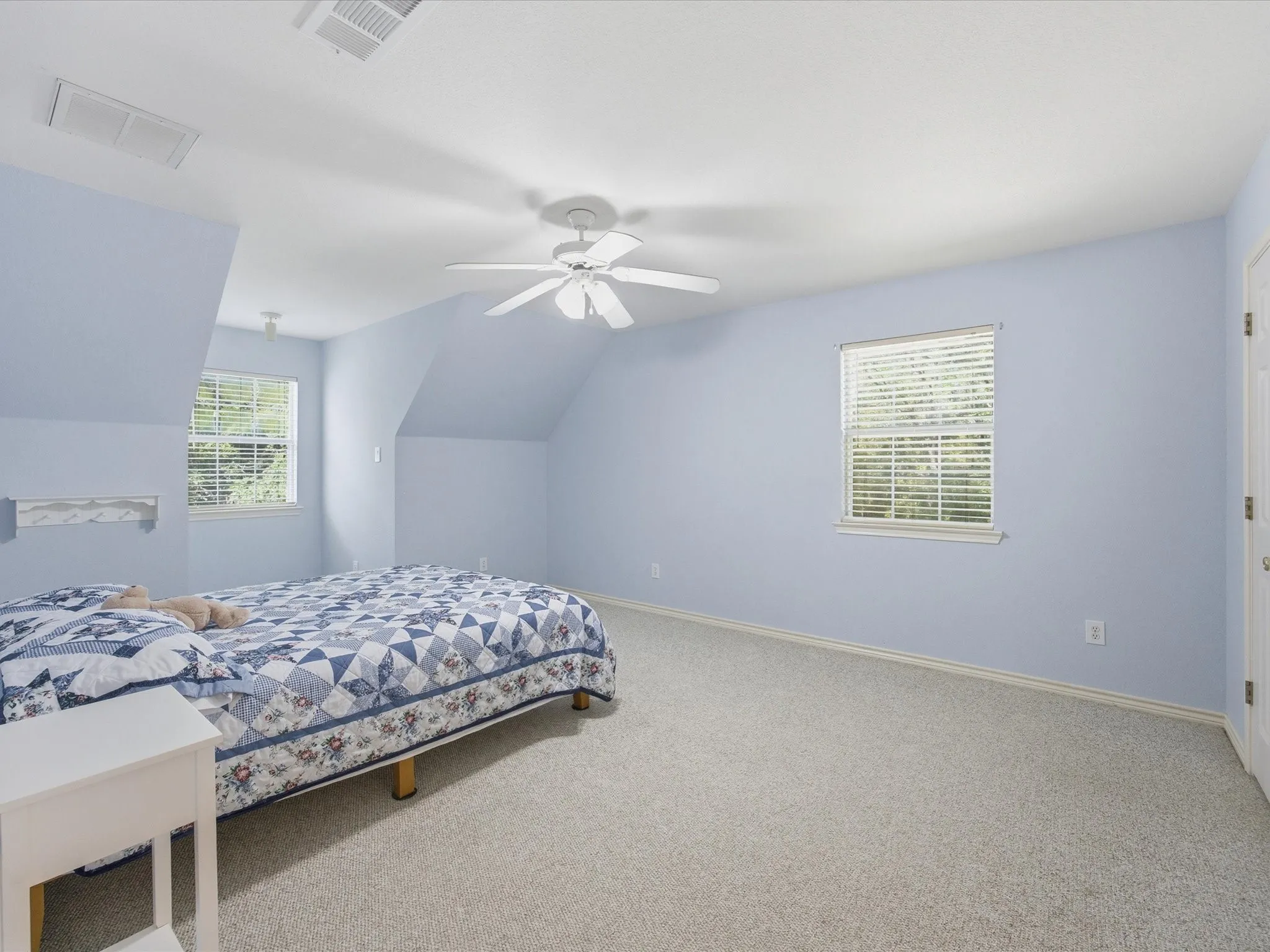 Upstairs 3rd bedroom with windows and ceiling fan with walk-in closet
