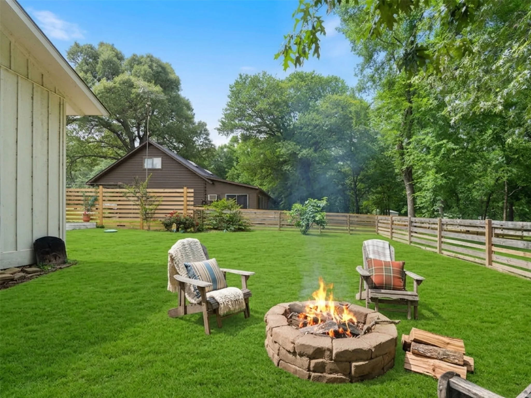 Expansive green lawn featuring a stone-clad fire pit
