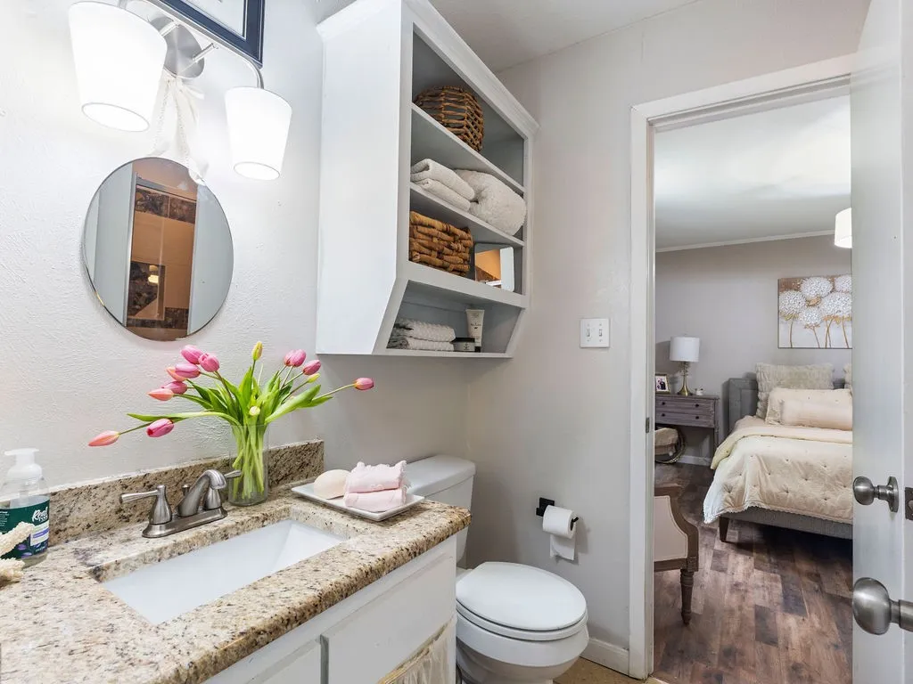 Bathroom vanity featuring a built-in sink, granite countertop, and brushed nickel faucet