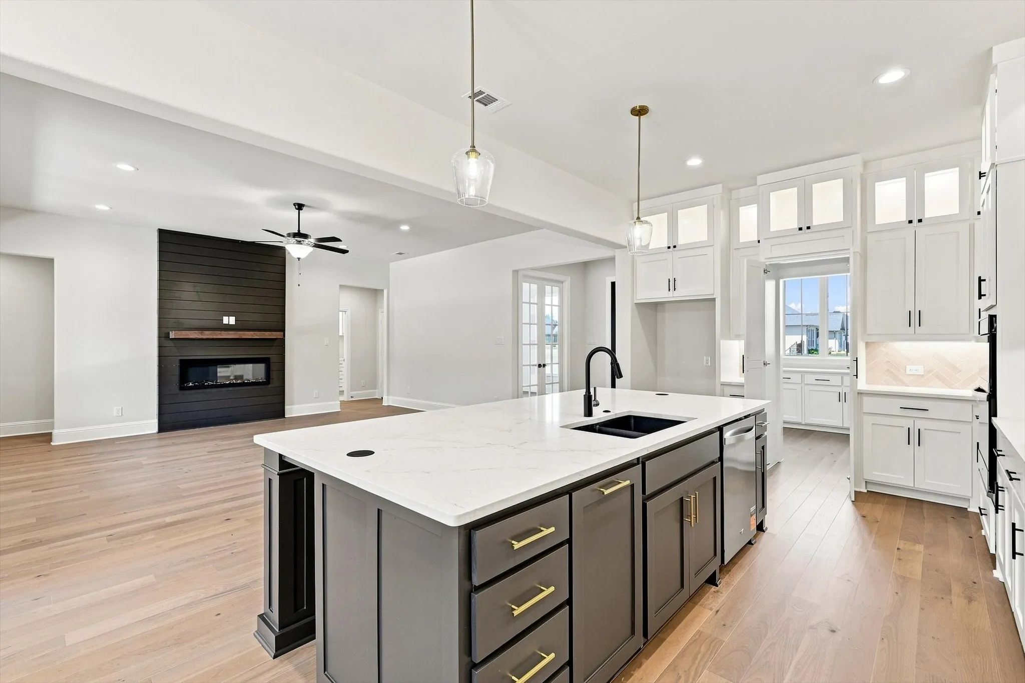 Kitchen island with white countertop, integrated sink, and pendant lighting