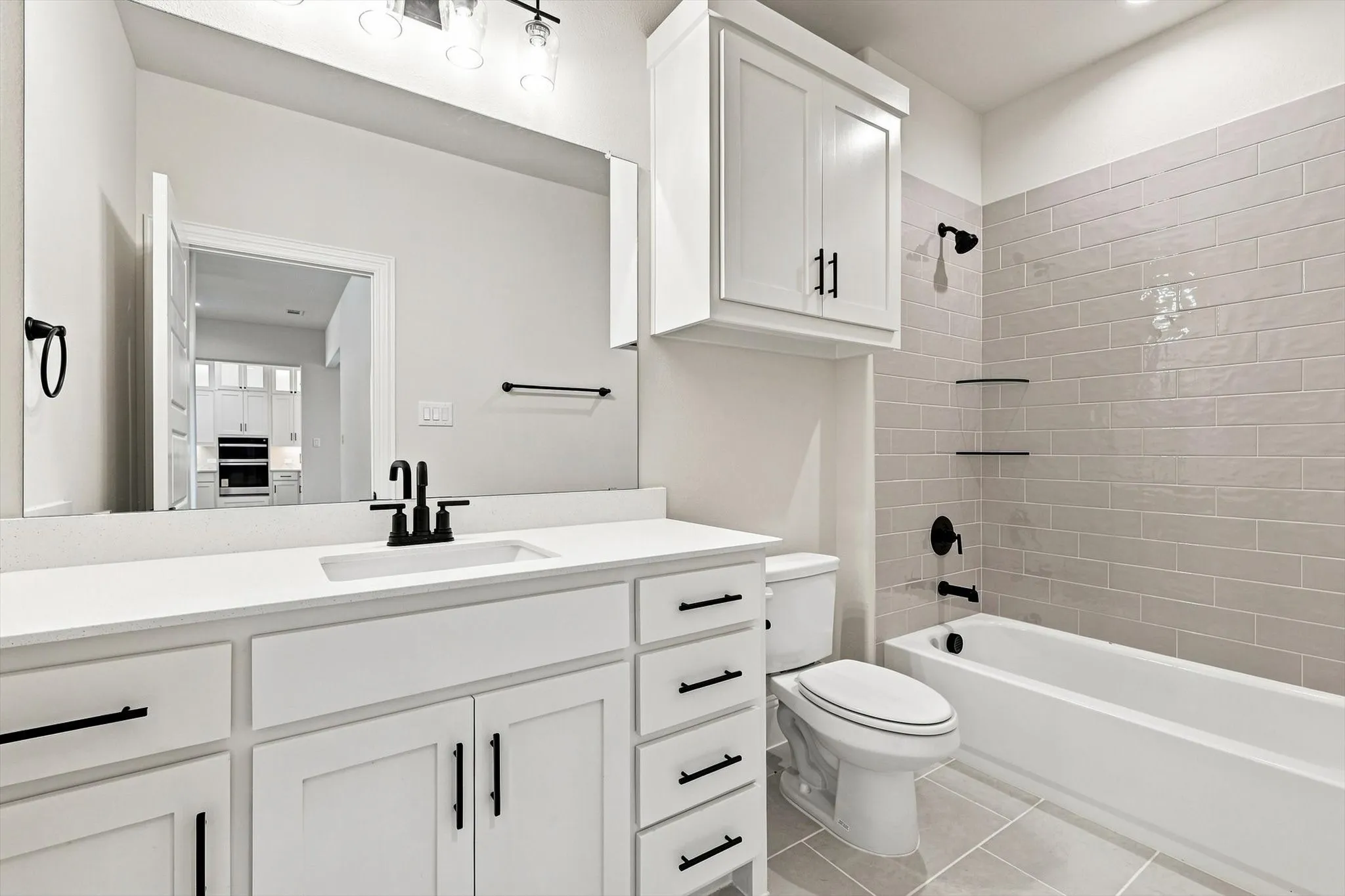 White vanity with quartz countertop, undermount sink, and matte black fixtures