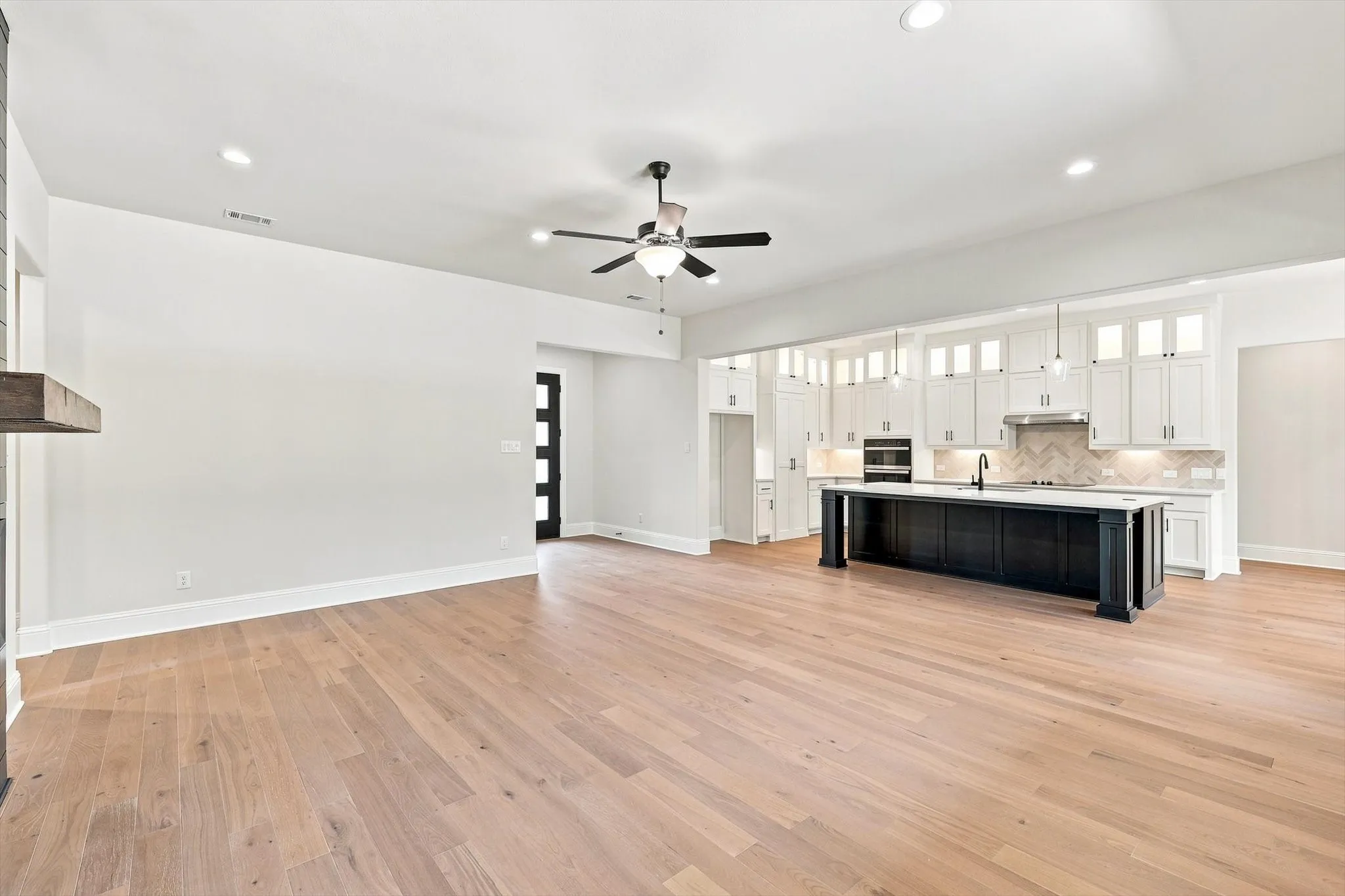 Wood-finish flooring throughout, recessed lighting, and a ceiling fan
