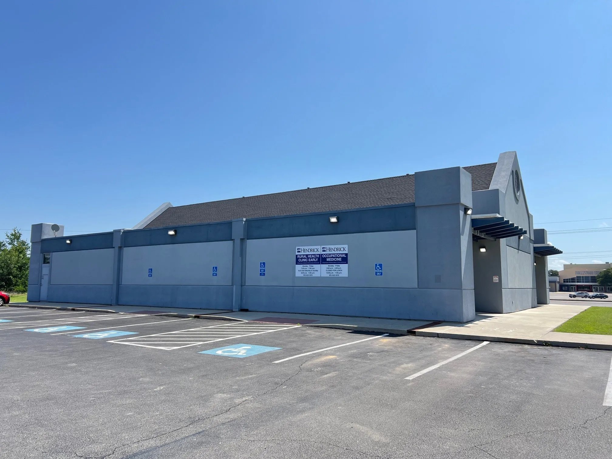 Commercial building with a dark shingle roof and a light gray and blue exterior