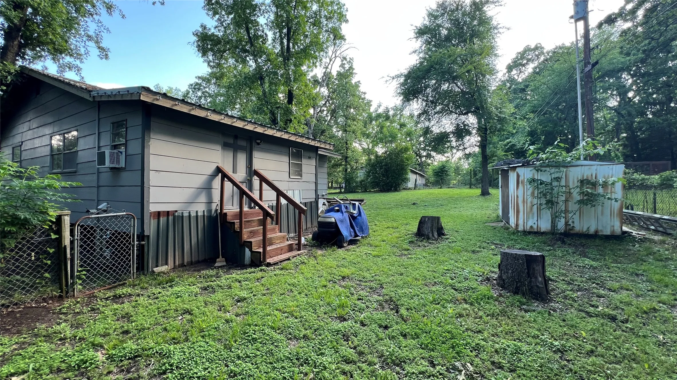 Backyard view of back of house and extra lot in the background