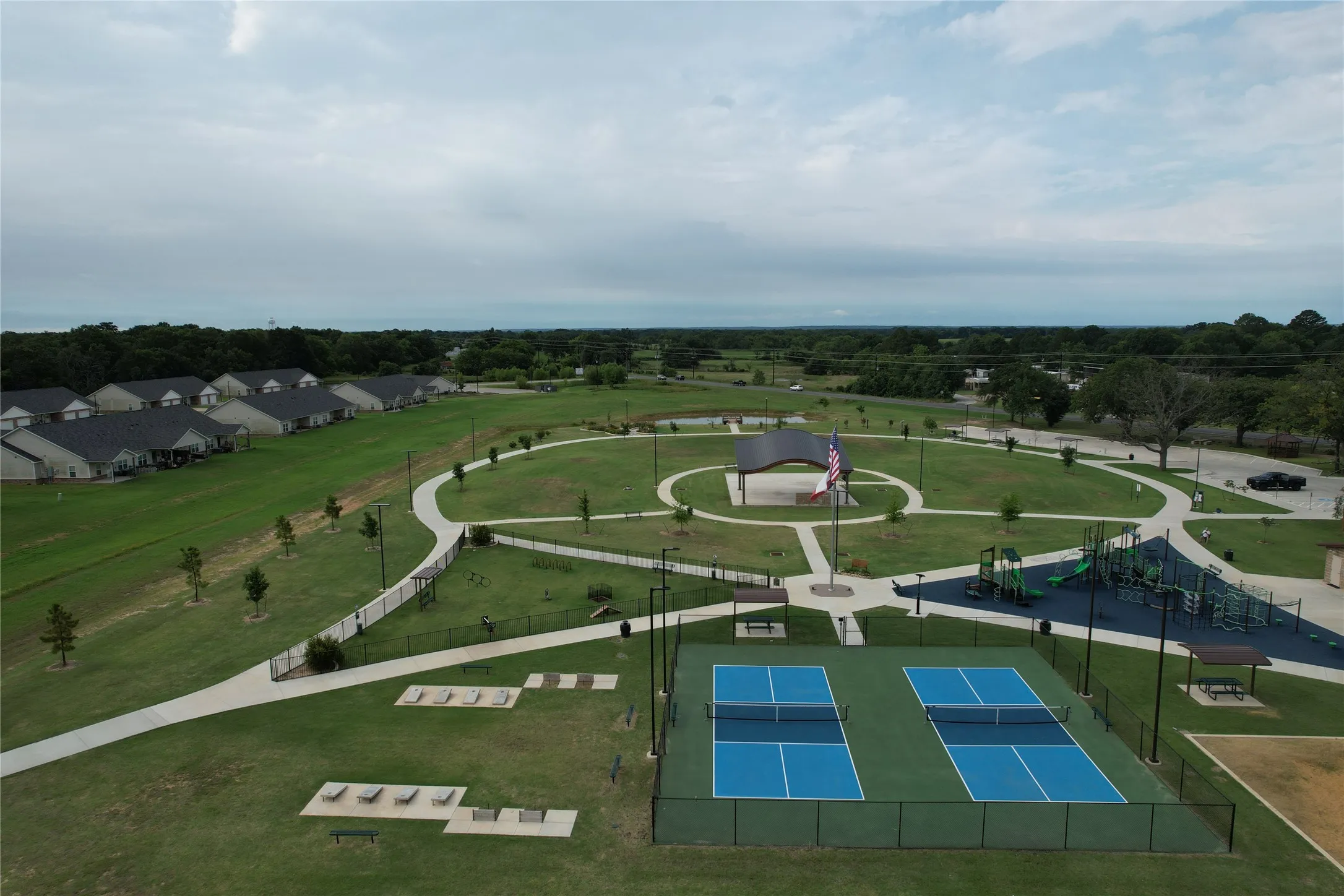 The Eight at Tool Park Community recreational area featuring two pickleball courts, a playground with multiple structures, a covered pavilion, walking paths, and a dog park all accessible from Cedar Crest Shores walking path near 613 Hilltop Drive