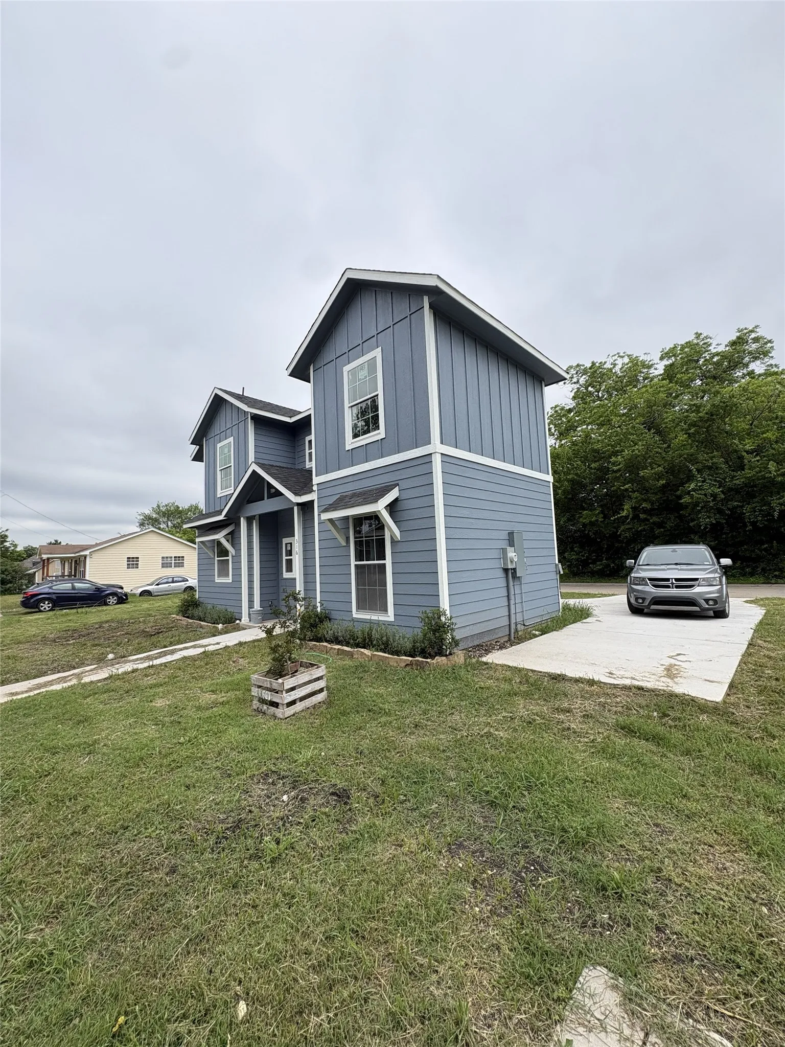 Contemporary two-story residence featuring light blue horizontal siding and vertical board and batten accents