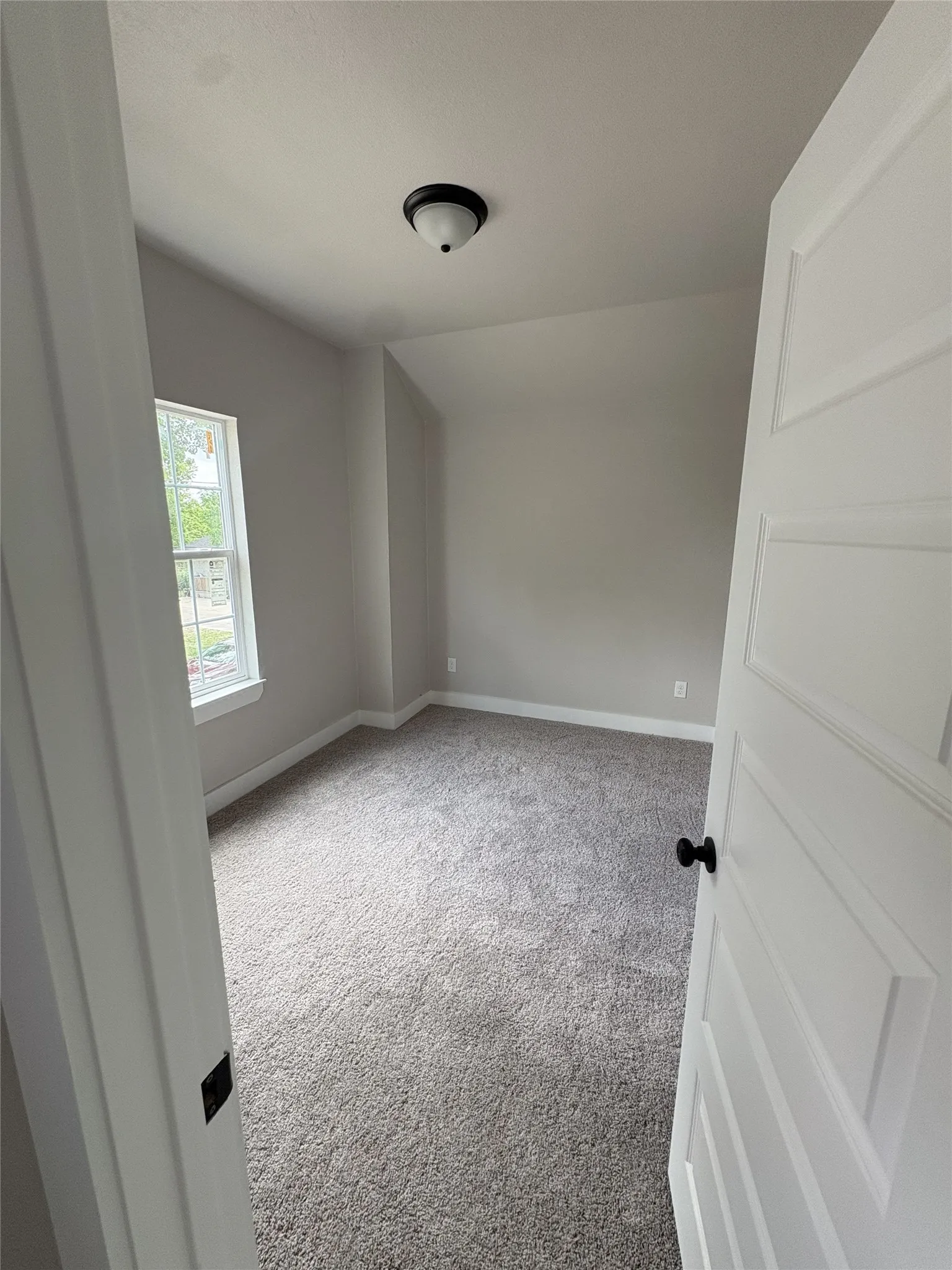 Neutral wall paint, plush grey carpeting, and white trim create a clean aesthetic