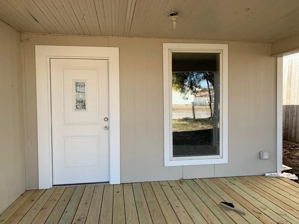 Inviting covered porch featuring natural wood decking