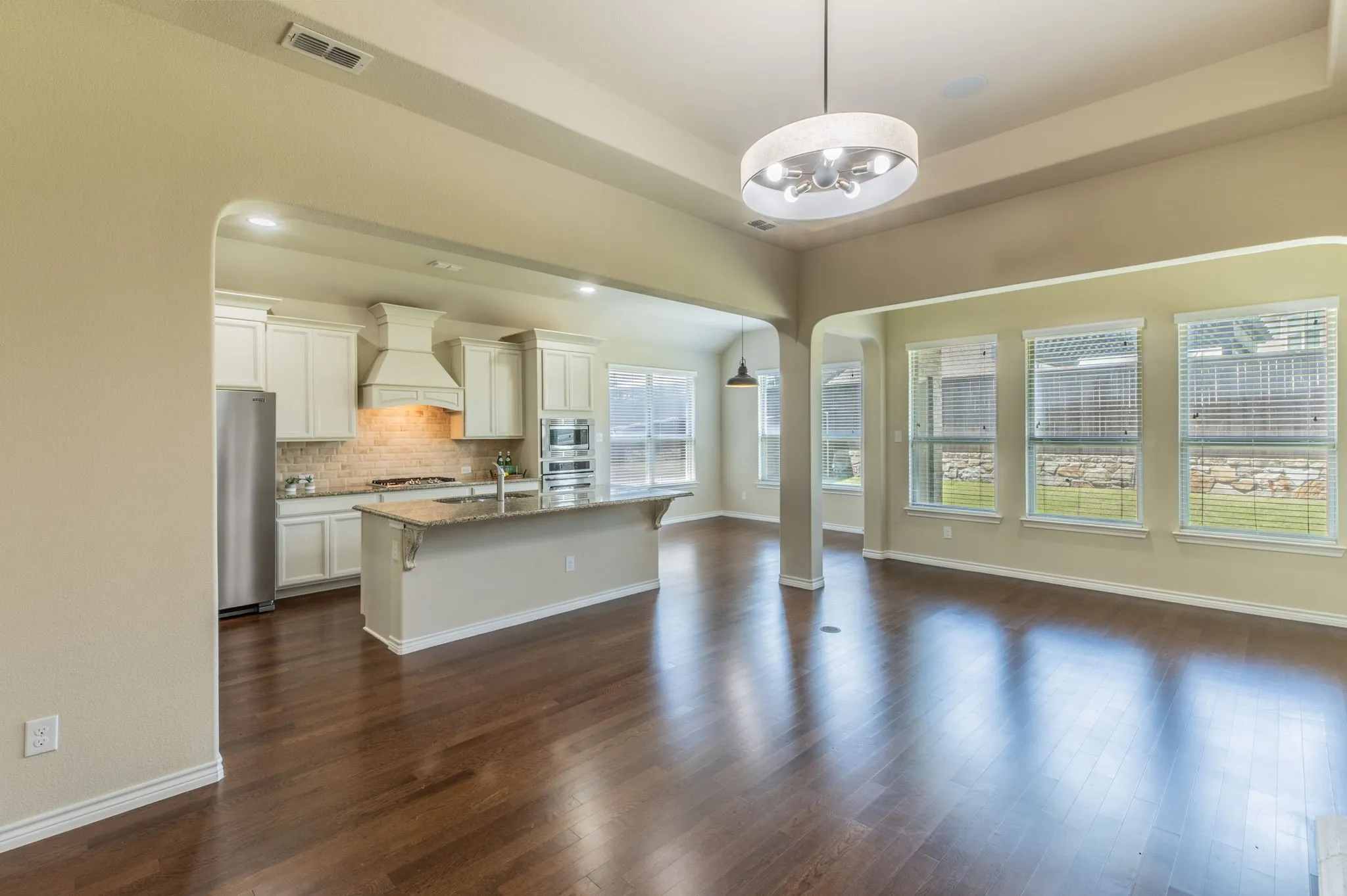 Living Room open plan to kitchen with wall of windows & architectural coffered ceiling