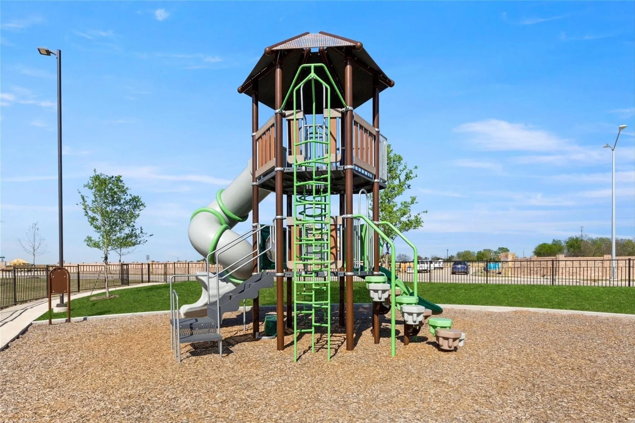 Recreational playground featuring a multi-level structure with a covered tower, spiral slide, and climbing elements