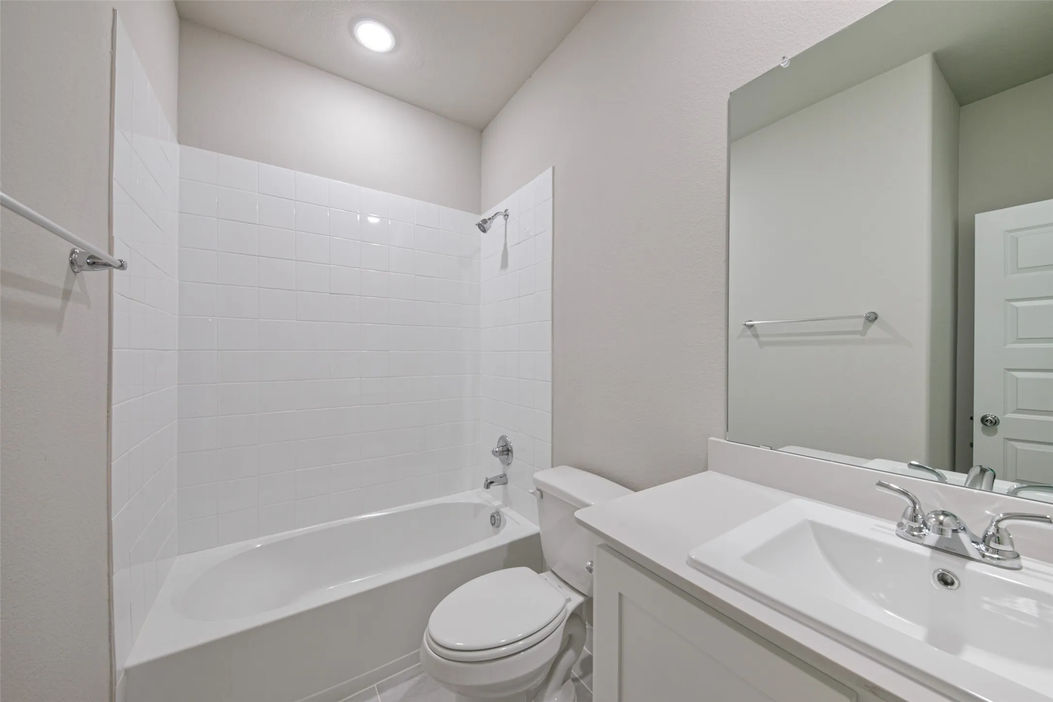 Bathroom featuring a white subway tile shower surround and a white built-in bathtub