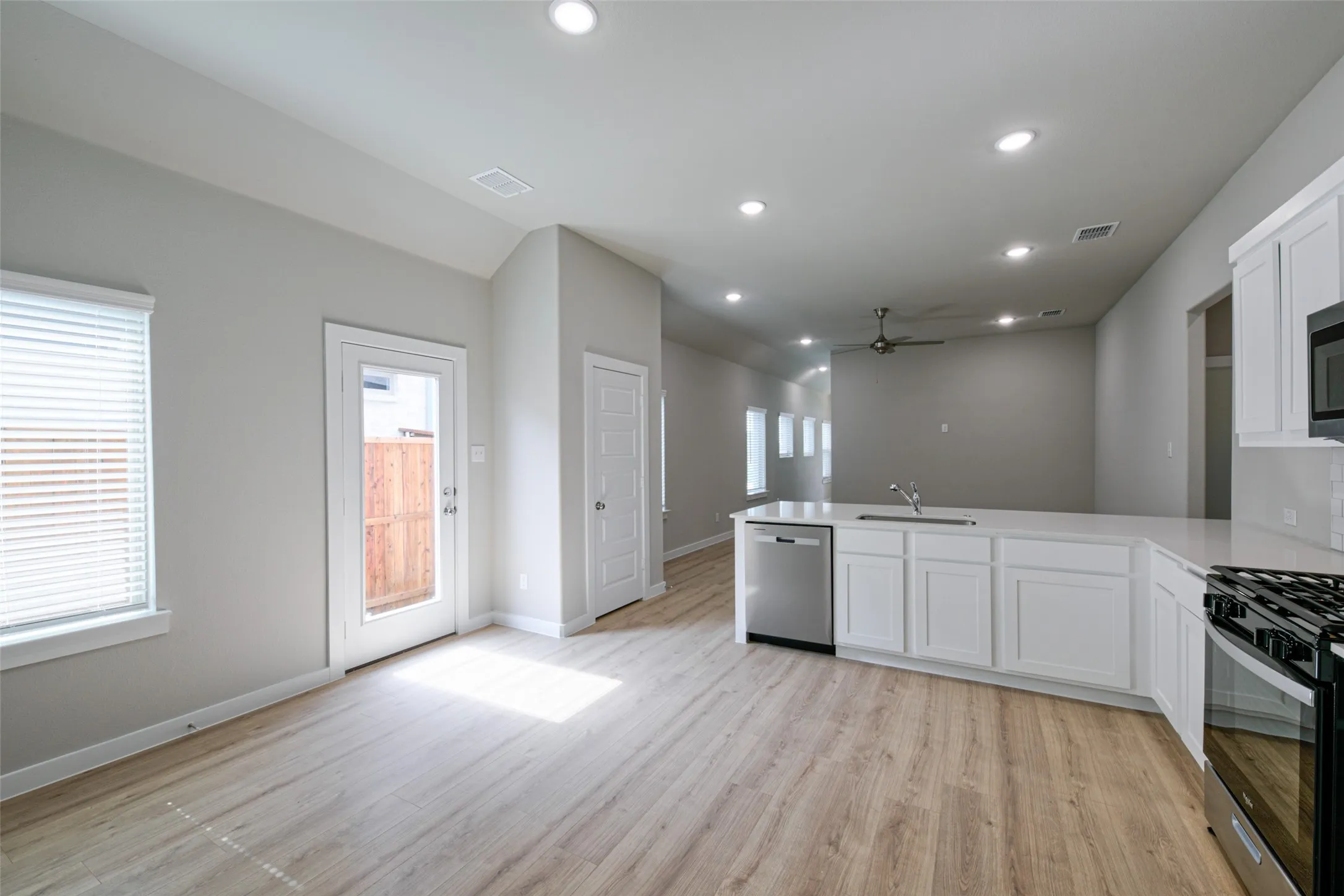 Open concept living space featuring wood-finish flooring, recessed lighting, and a modern kitchen
