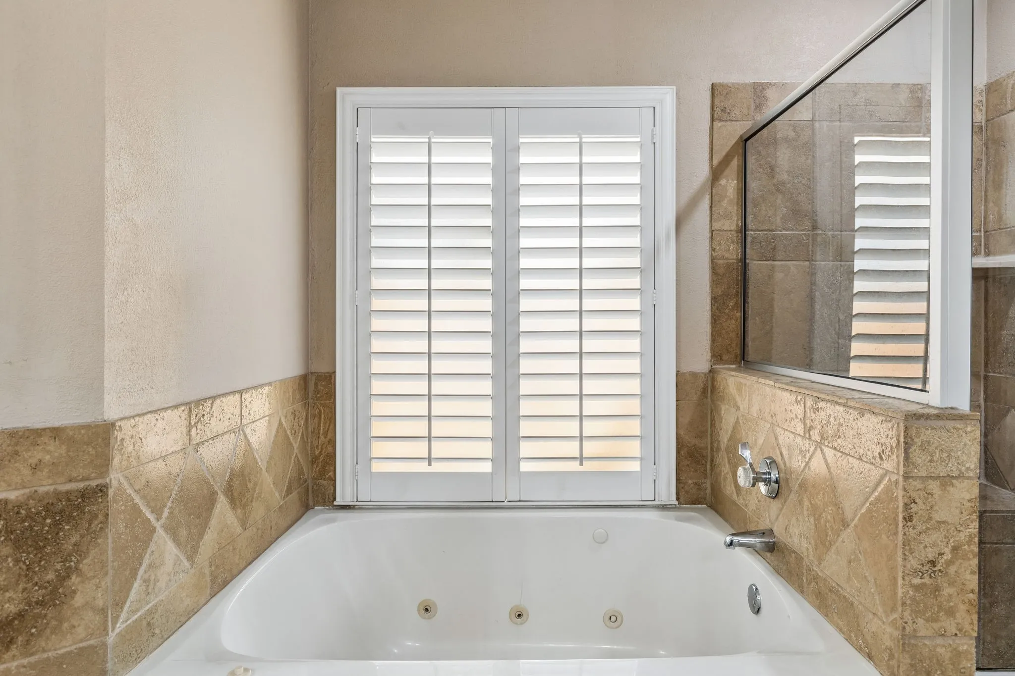 Jetted tub with separate shower have stylish tile surround.