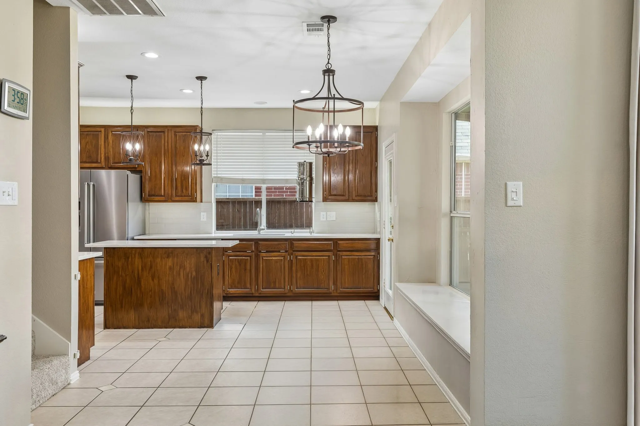 Thoughtfully laid out, the nook offers a window seat and stylish light fixture that coordinates with the pendant lights over the kitchen island. To the left of the stairway shown, is a door that leads to under the stair storage.