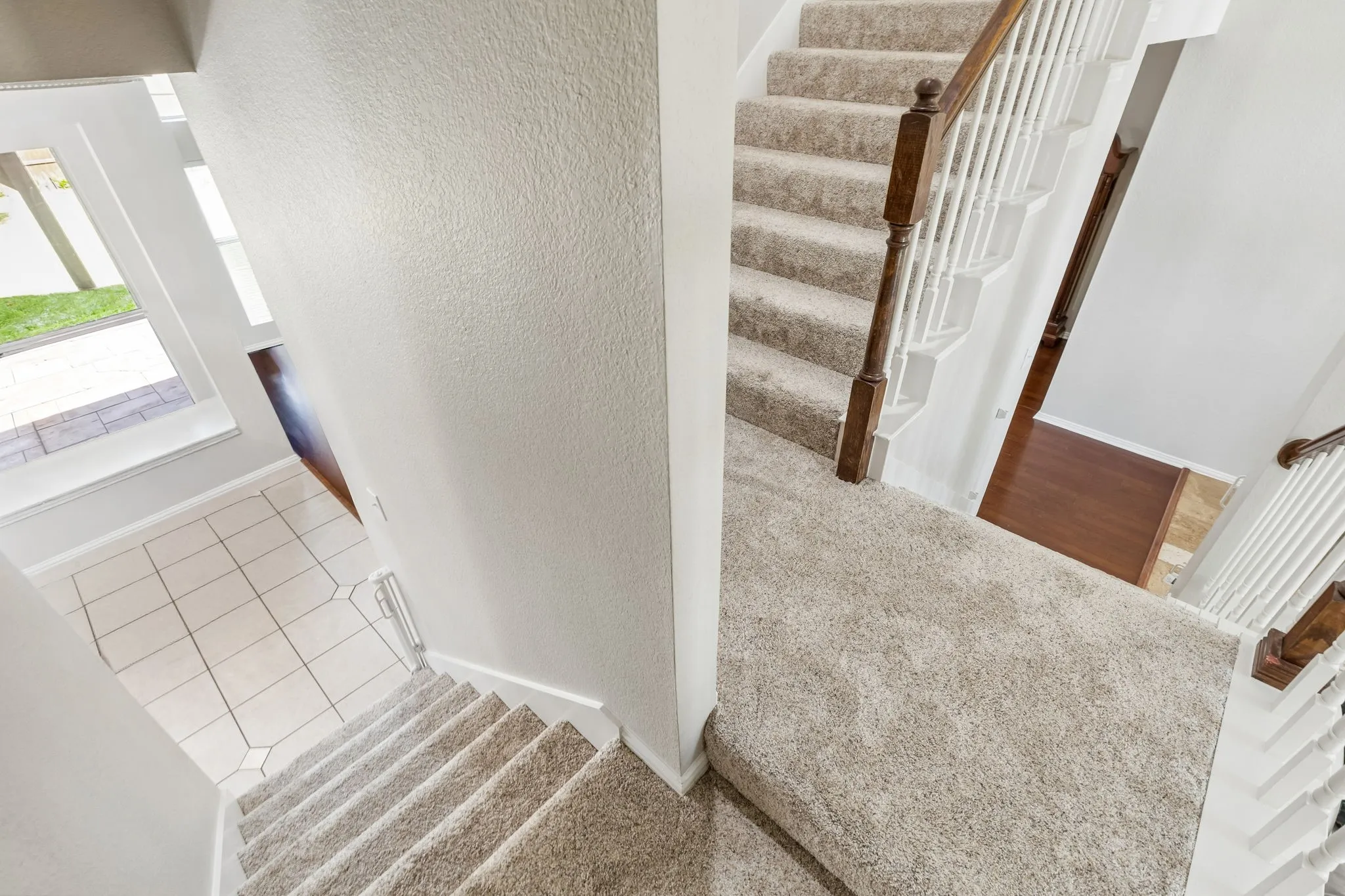 The stairs split from the landing to either the kitchen or the entry. So convenient! Find awesome storage under the stair!