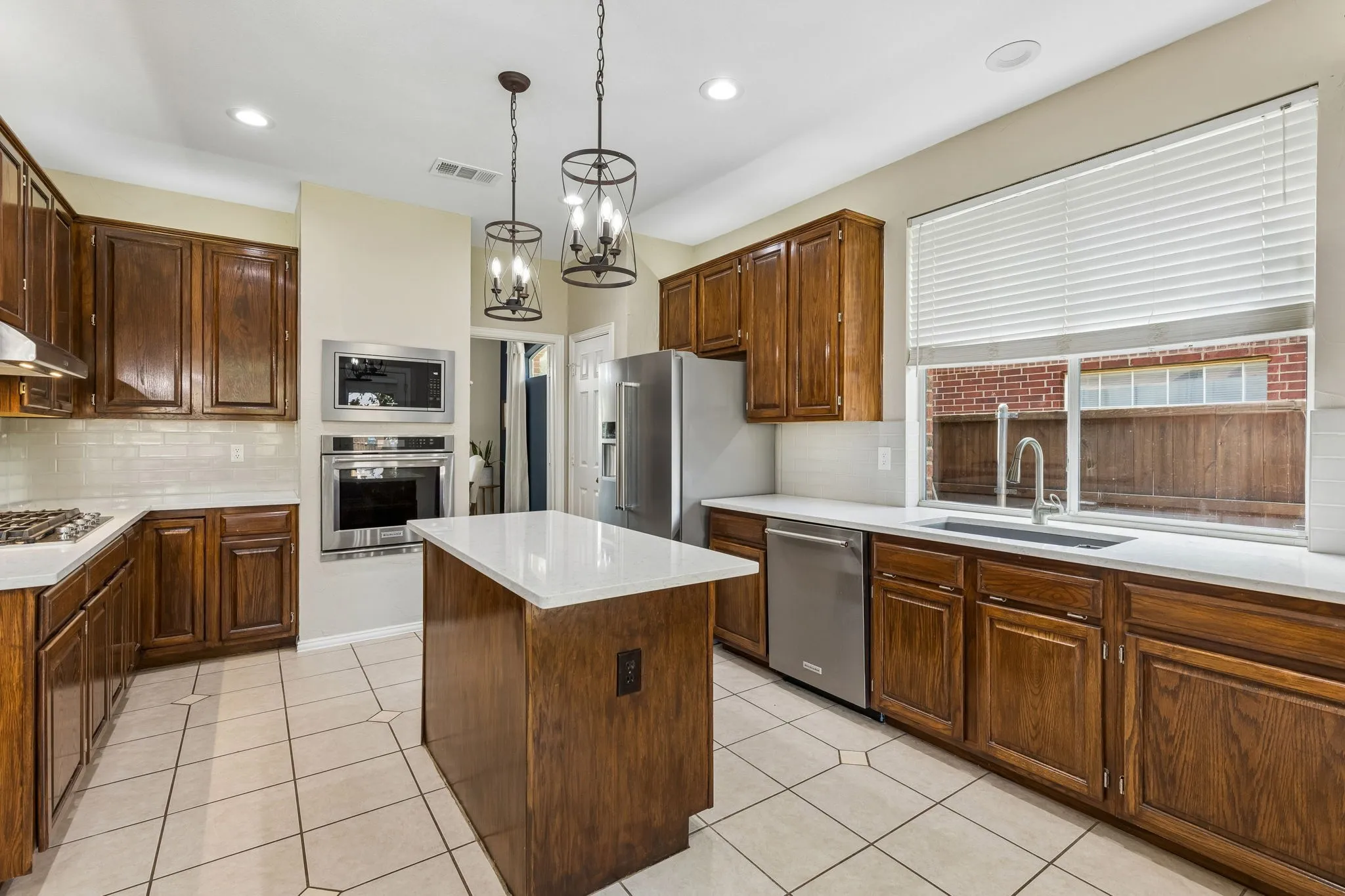 The kitchen boasts a blanco sink with window overlooking the work area. Under the sink find an 8 gallon hotwater heater for instant hot water. Other features of the space: 5 burner gas cooktop and stainless appliances including convection oven and a wall mounted microwave.