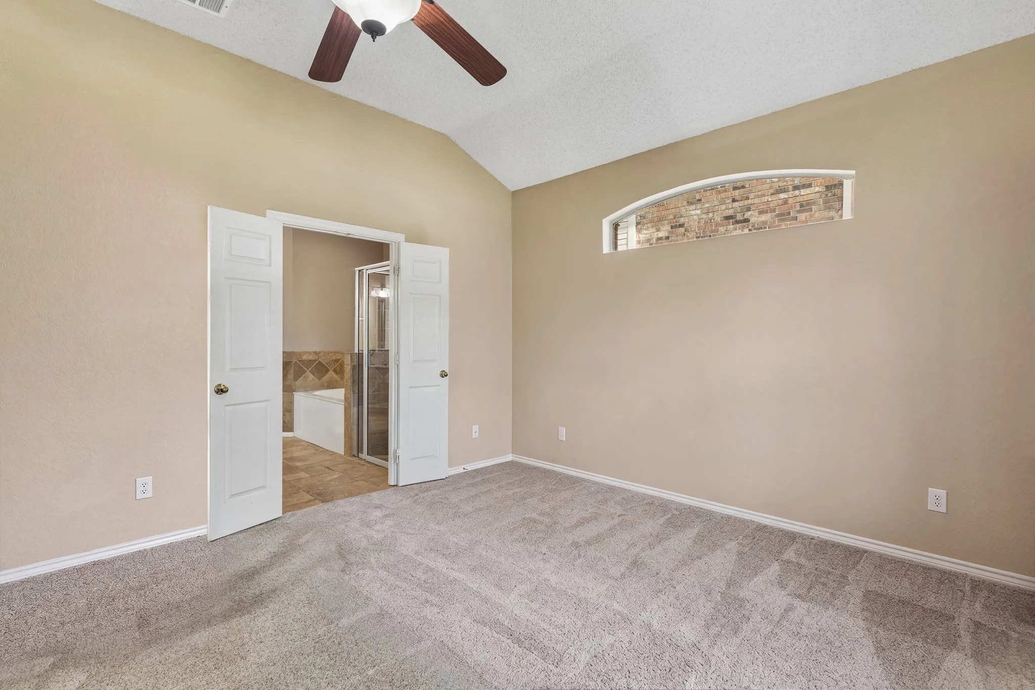 Access the spacious primary bath through french doors. The space also has a large walk in closet.