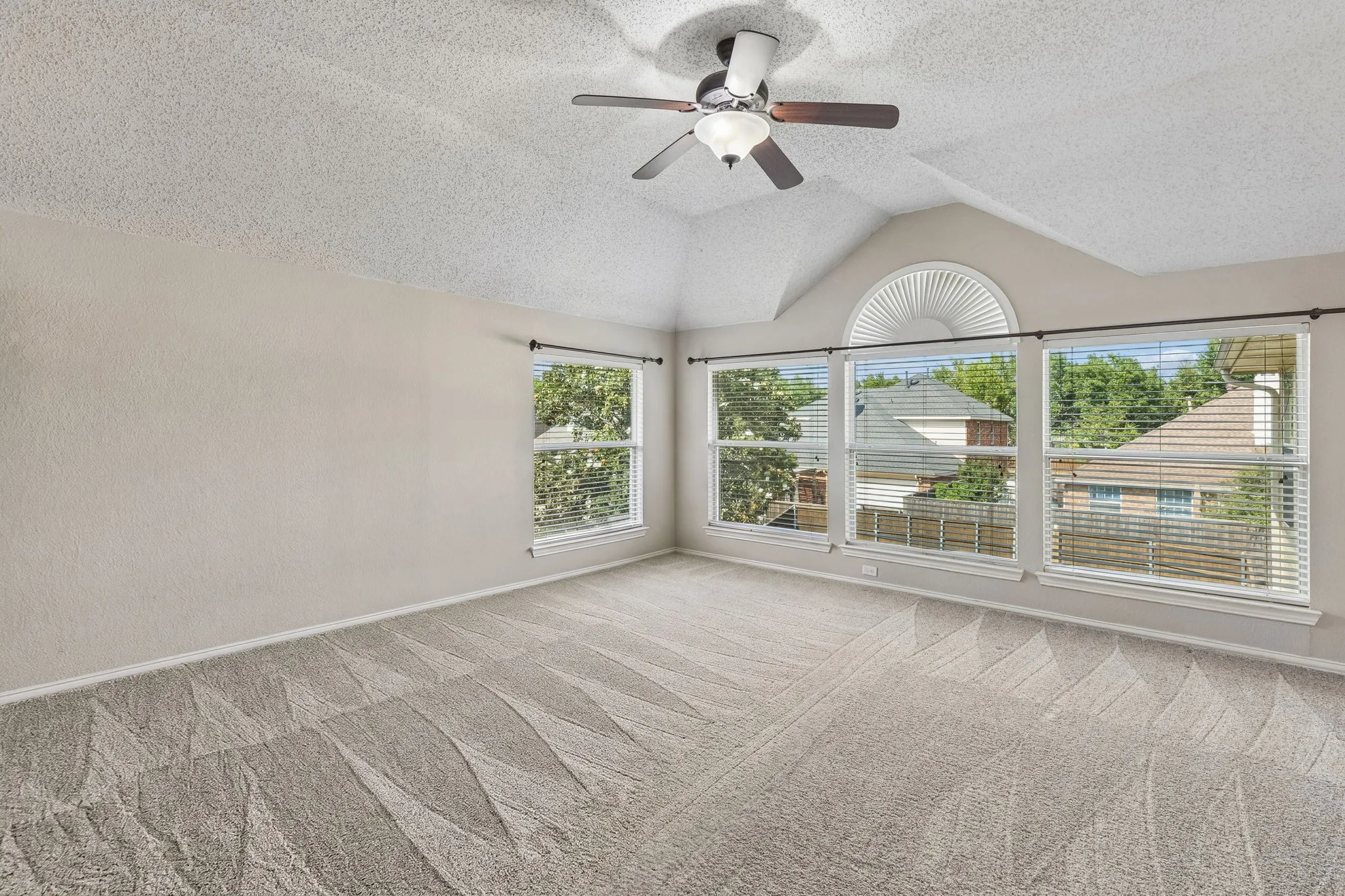 Find this large game room on the second floor. The space offers a wall of windows, ceiling fan and carpet.