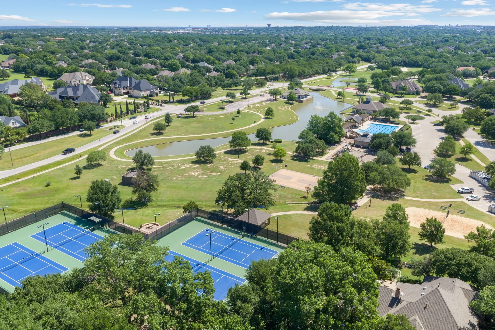 Expansive community amenities including multiple tennis courts, a large swimming pool, two ponds, and extensive green spaces