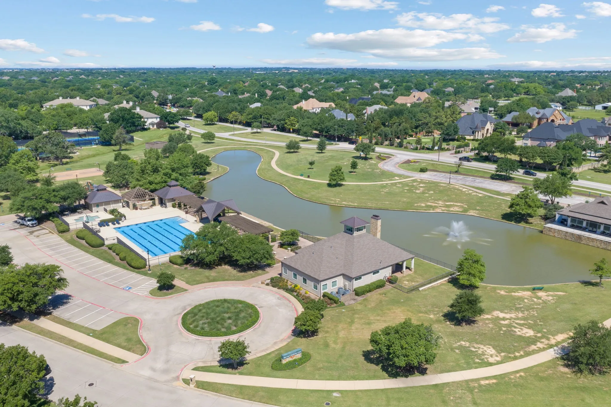 Community amenities featuring a swimming pool, winding pathways, and a pond with a water feature