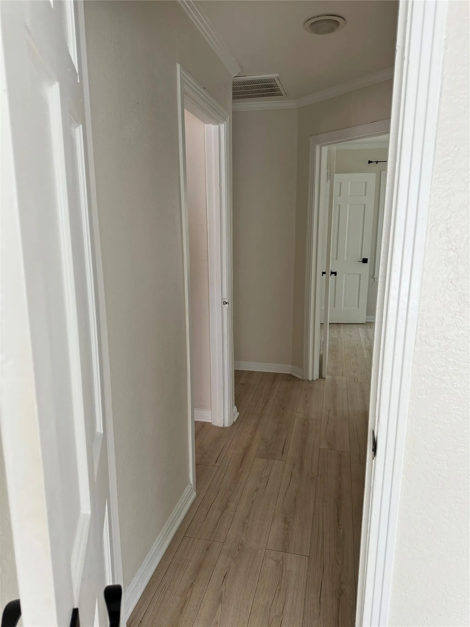 Hallway featuring wood-finish flooring, white trim, and recessed lighting