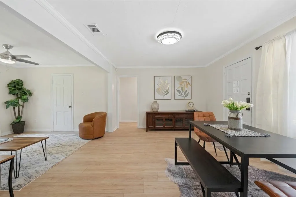 Wood-finish flooring throughout, featuring a contemporary ceiling fan, a modern flush-mount light fixture, and a paneled entry door
