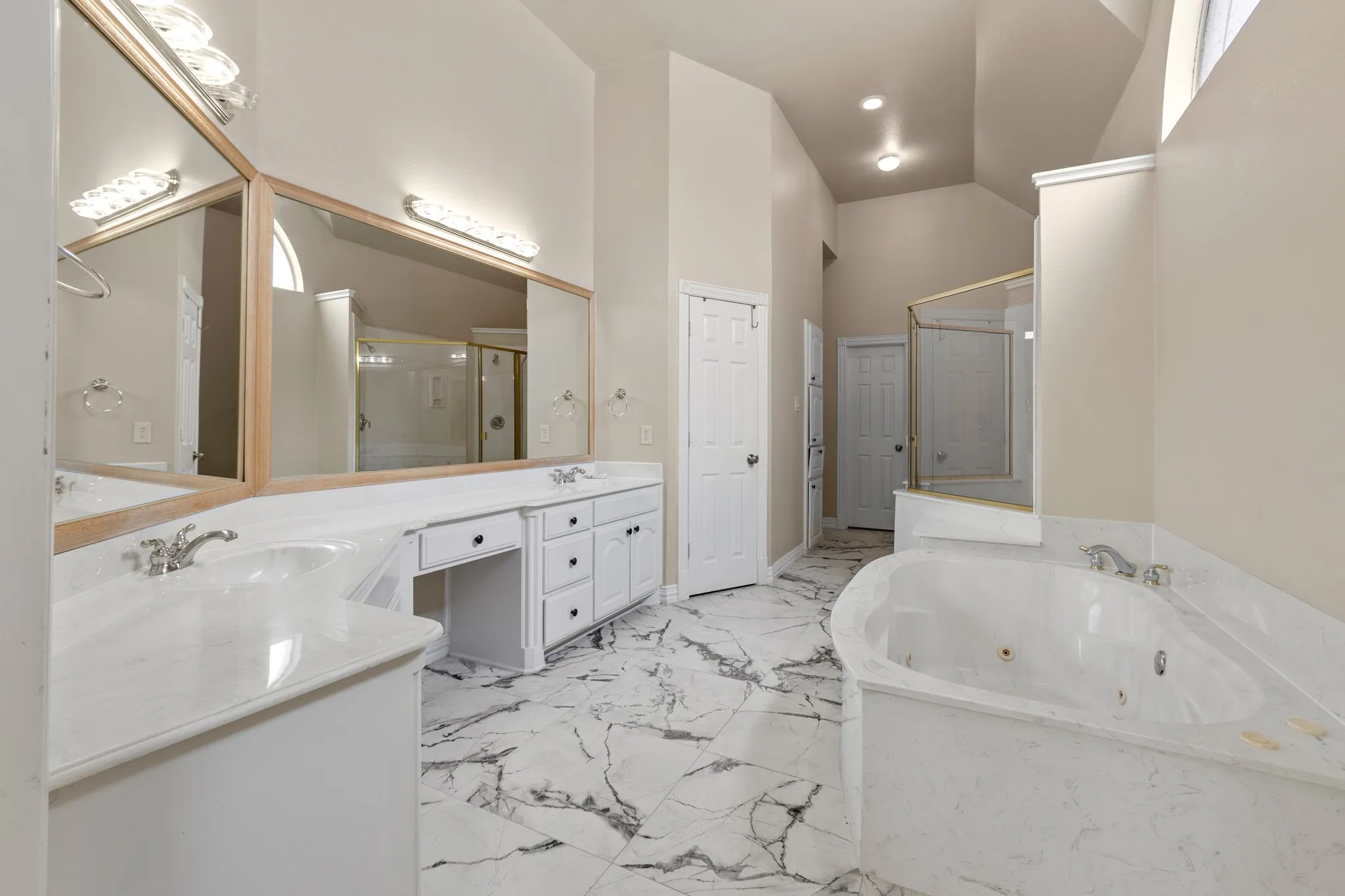 Bathroom featuring double vanity, tile flooring, high vaulted ceiling, and shower with separate bathtub