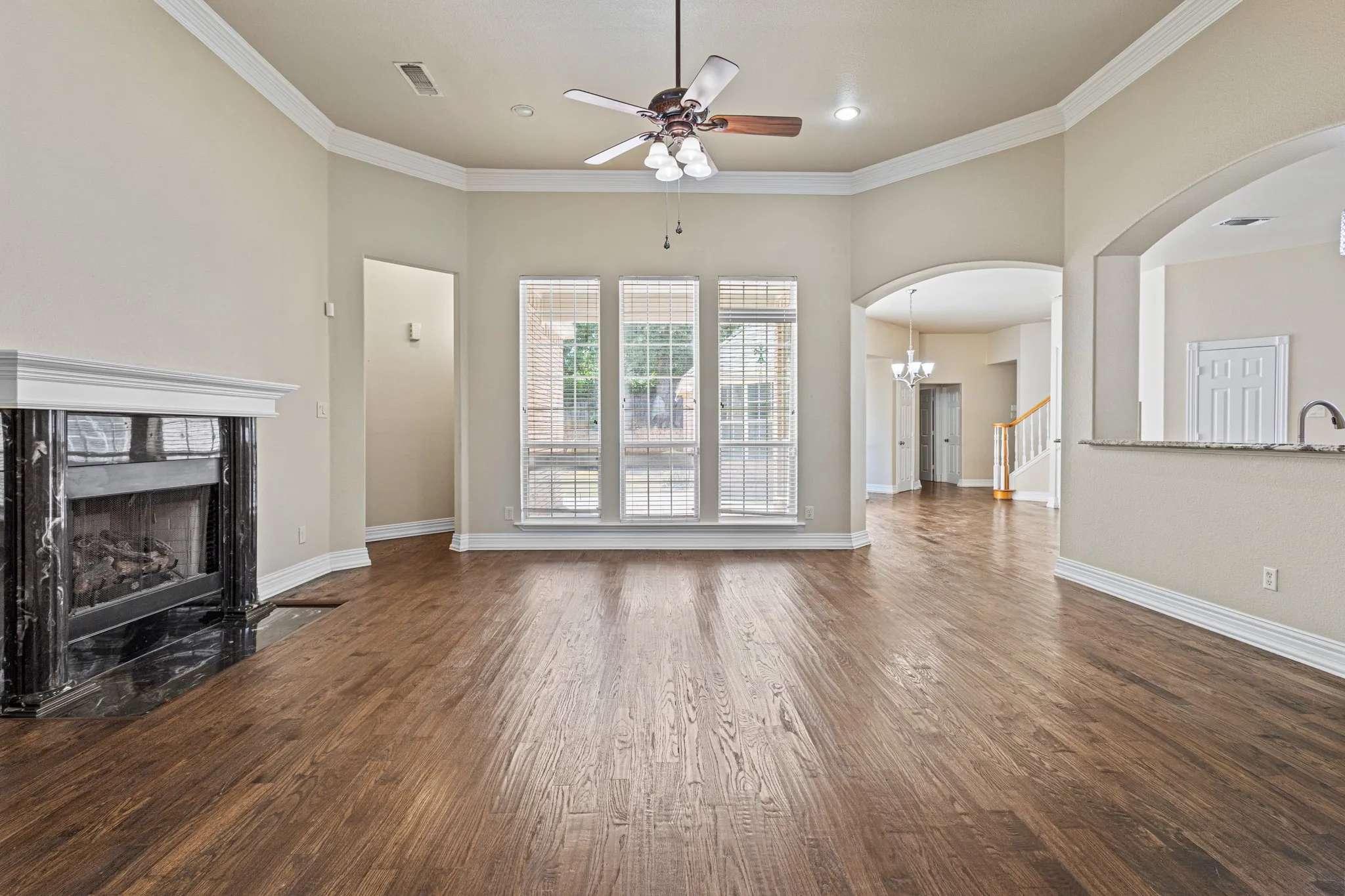Unfurnished living room featuring dark hardwood / wood-style floors, a high end fireplace, and crown molding