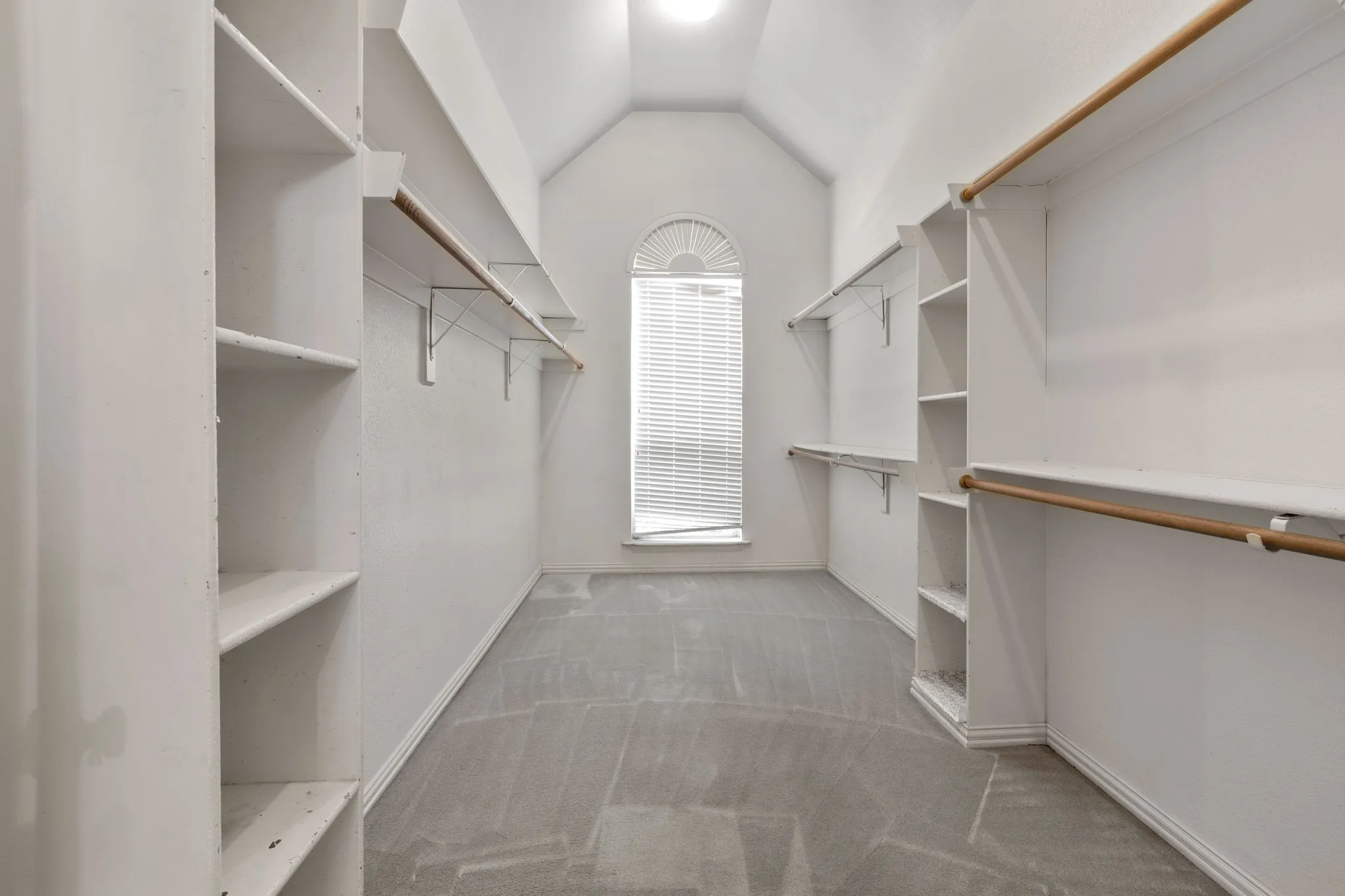 Spacious closet with carpet flooring and vaulted ceiling