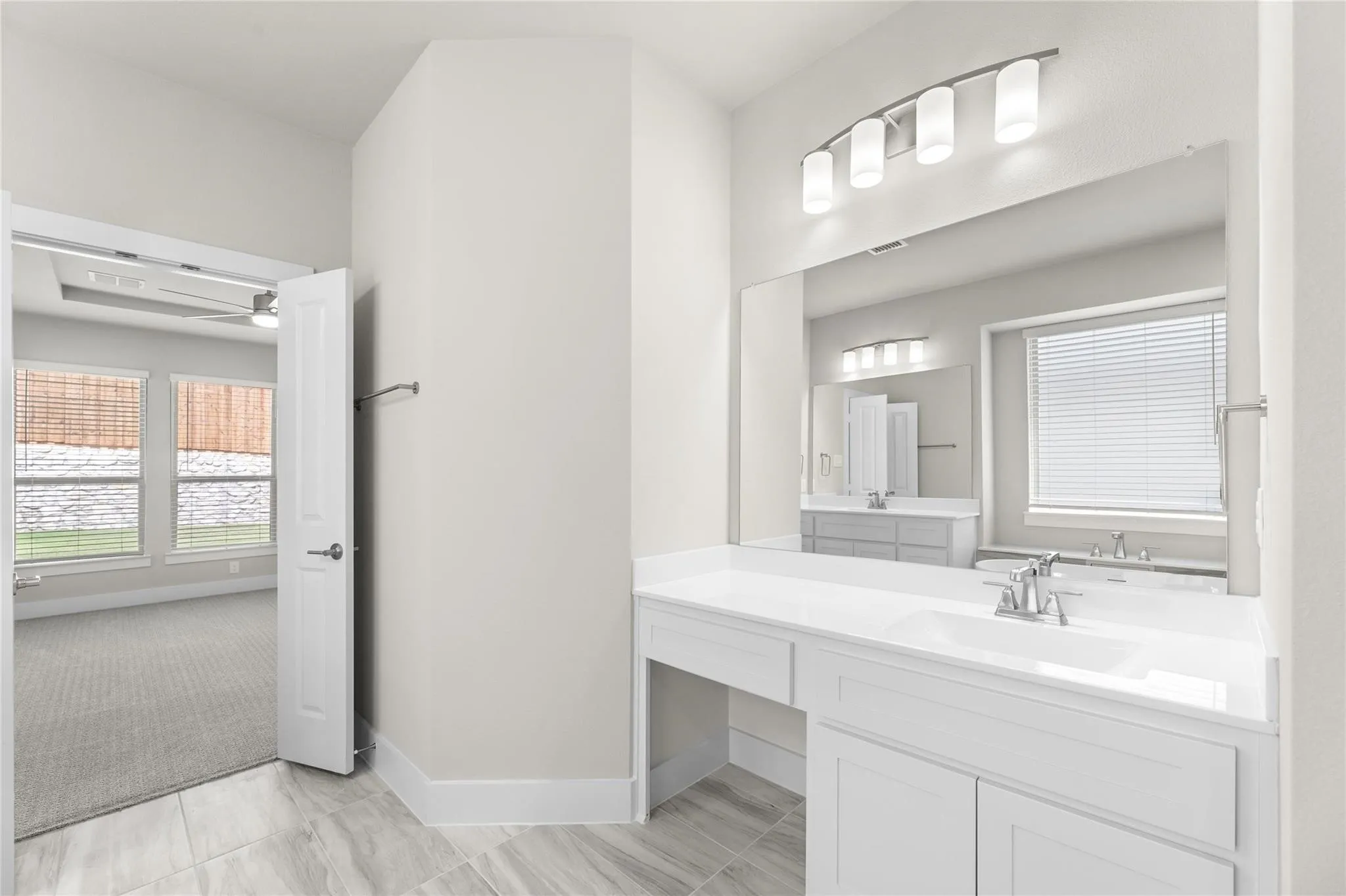 Bathroom featuring a double vanity with white cabinetry, integrated sinks, and chrome faucets
