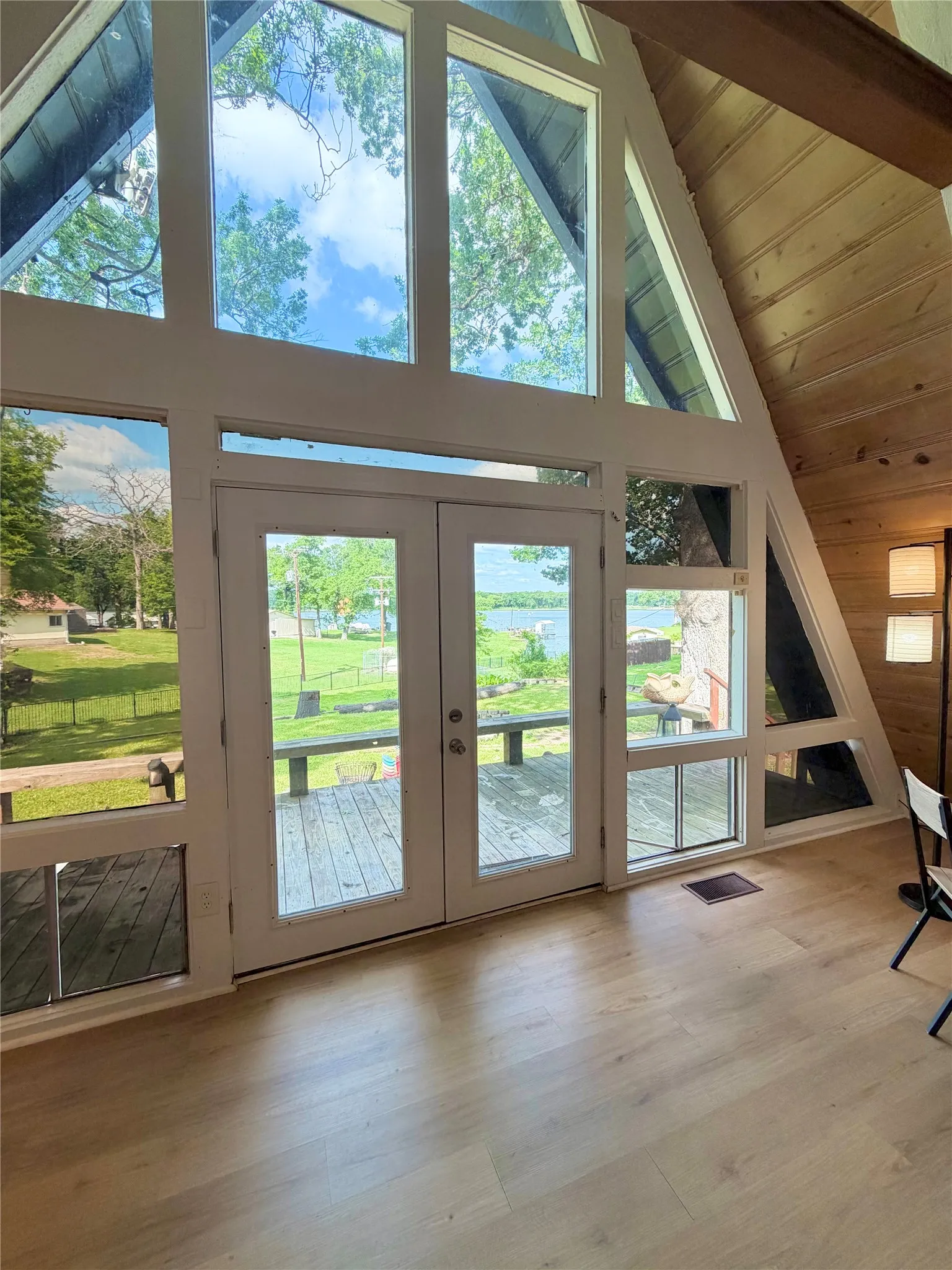 Stunning floor-to-ceiling windows and elegant glass French doors fill the home with natural light