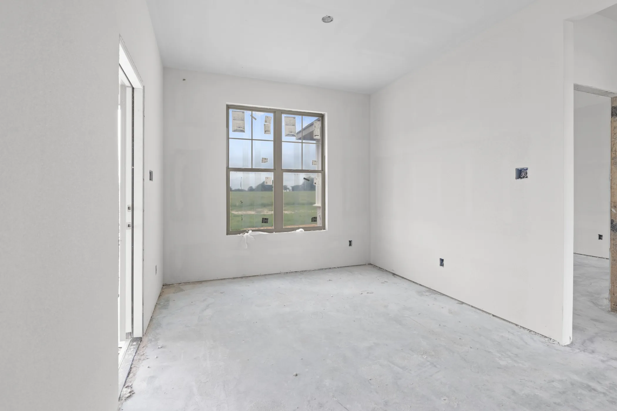 Unfinished interior space with neutral walls and a large window providing ample natural light