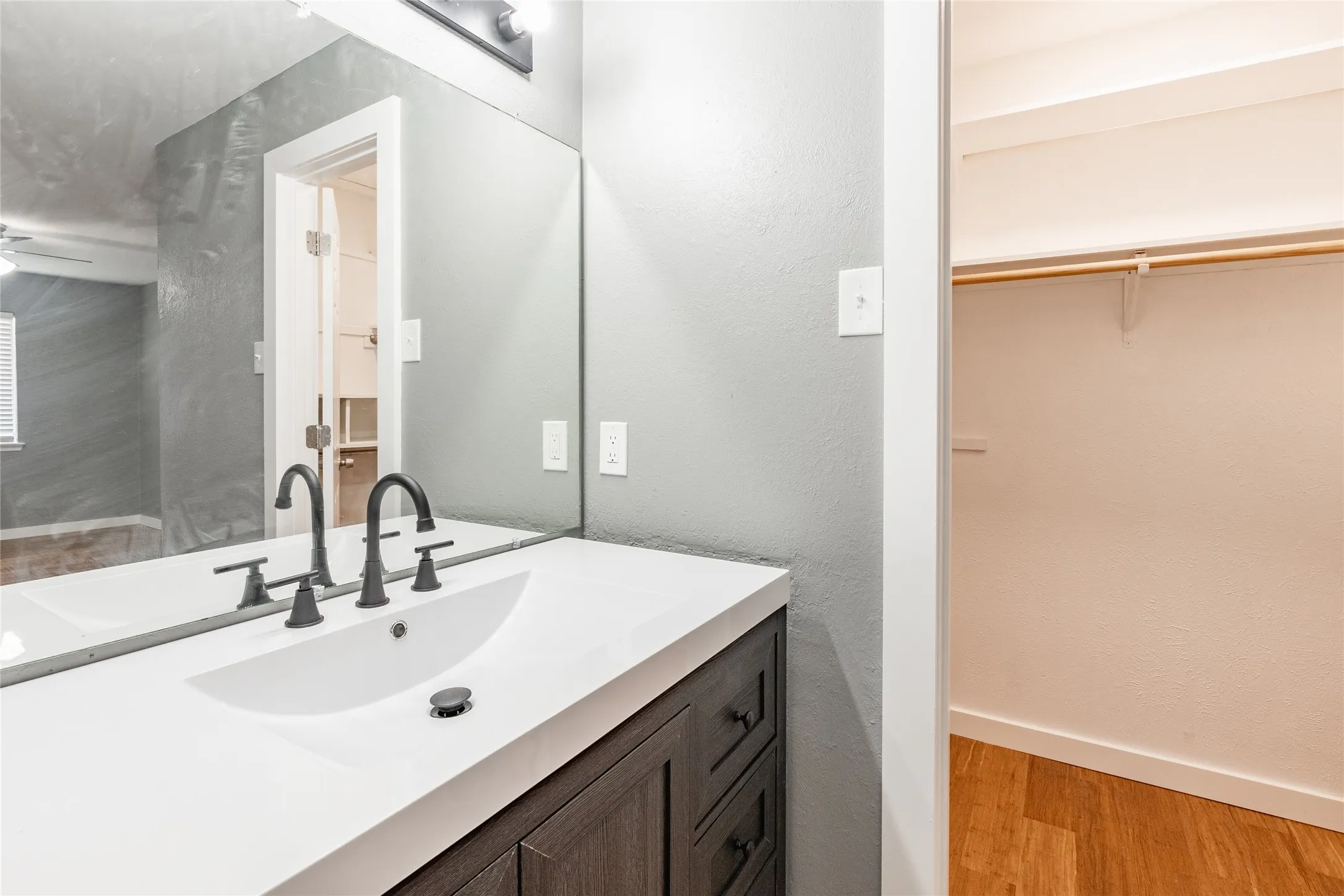 Bathroom vanity featuring a white countertop, under-mount sink, and matte black fixtures