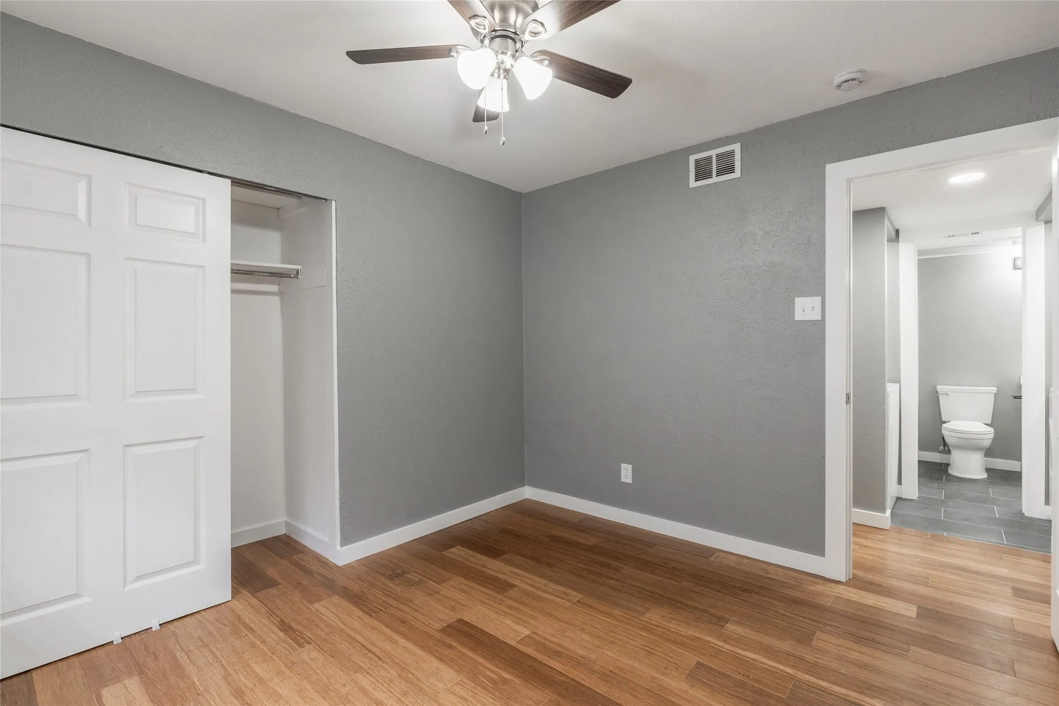 Wood-finish flooring complemented by a neutral wall color and white baseboards