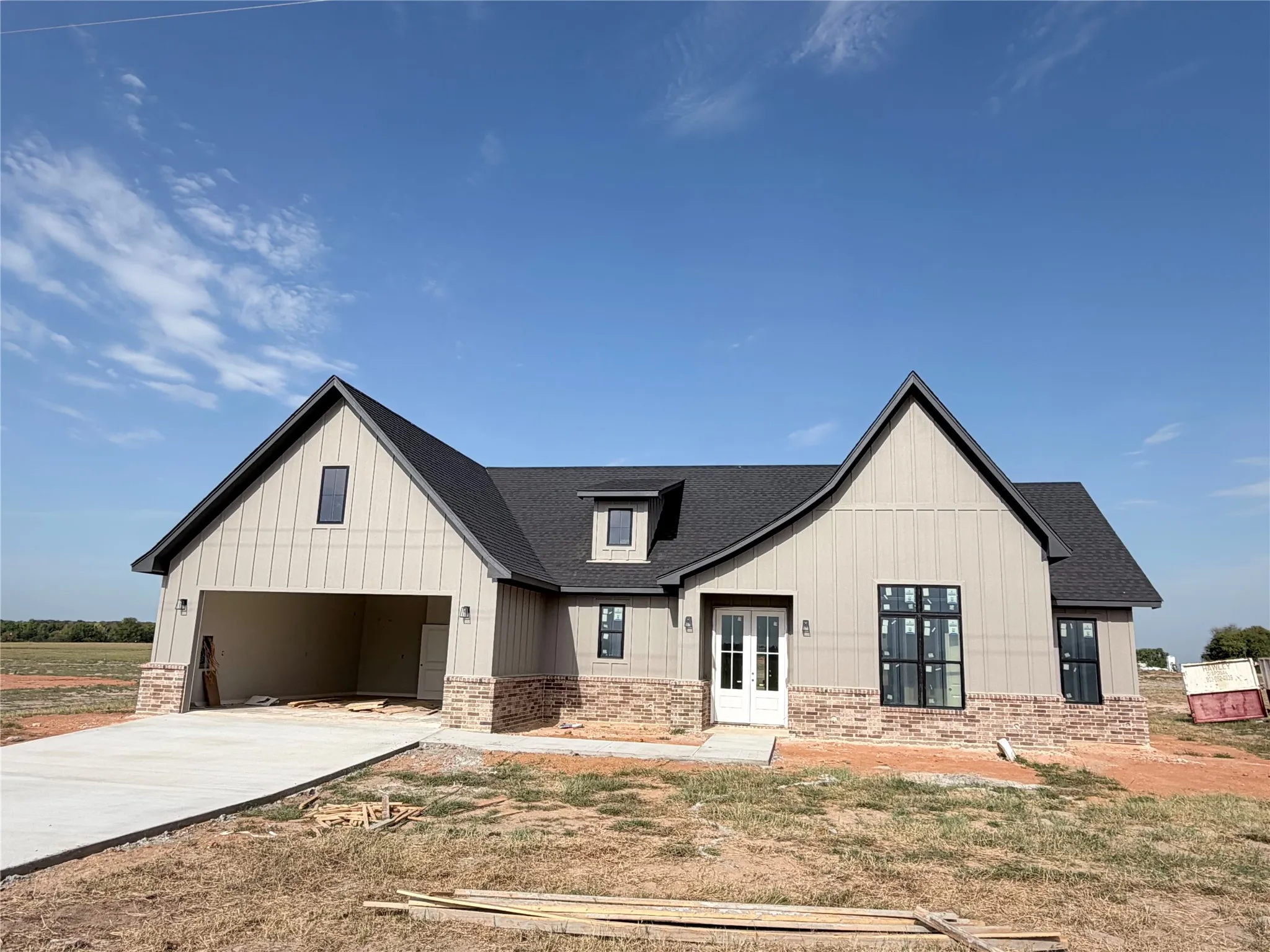 Contemporary facade featuring board and batten siding, stone accents, a double entry door, and a multi-paned window