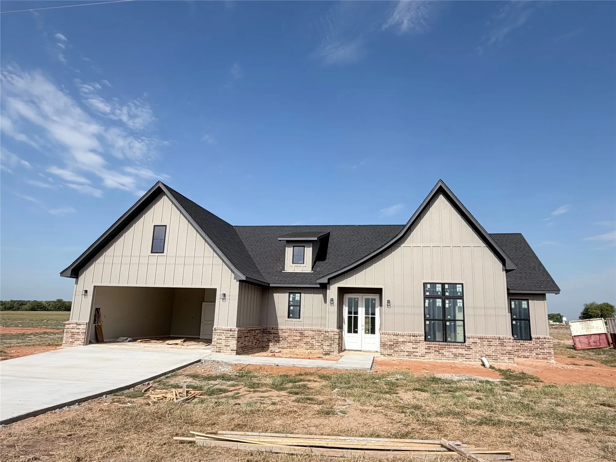 Contemporary exterior with board and batten siding, stone accents, dark shingles, and a dual-pane front entry door
