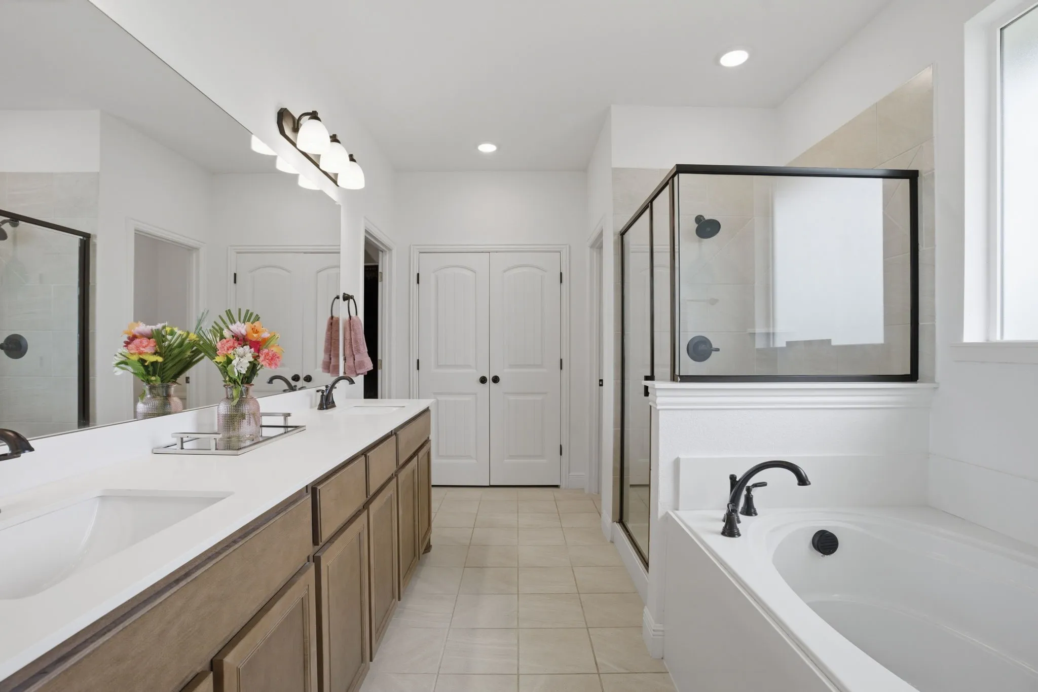 Another favorite feature of the sellers---this oppulent primary bathroom. Love the cabinet color that compliments the floor tile. A roomy walk-in primary closet straight ahead.